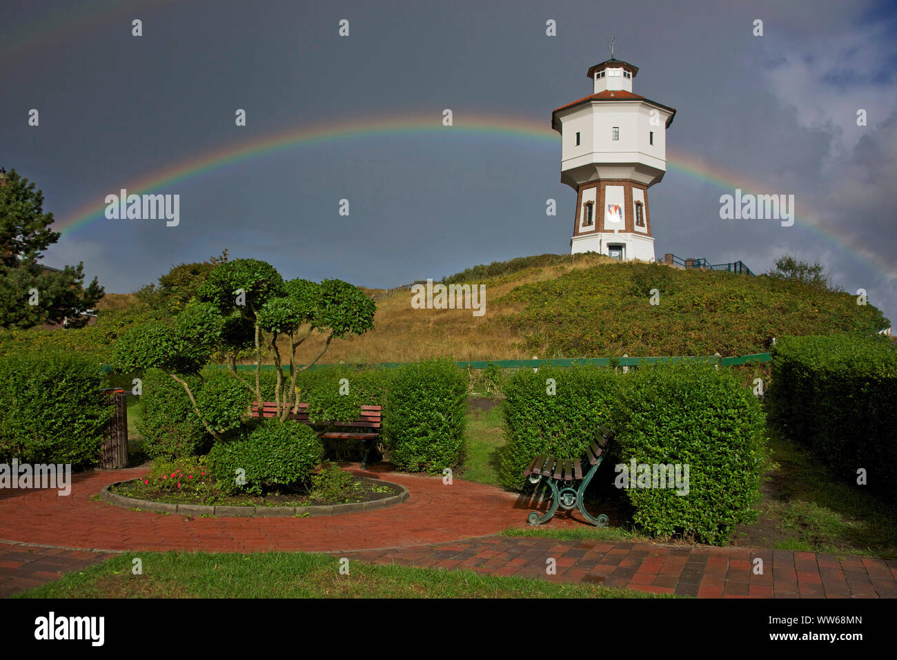 View from a small park on a rainbow behind the old water tower, the landmark of the island Langeoog. Stock Photo