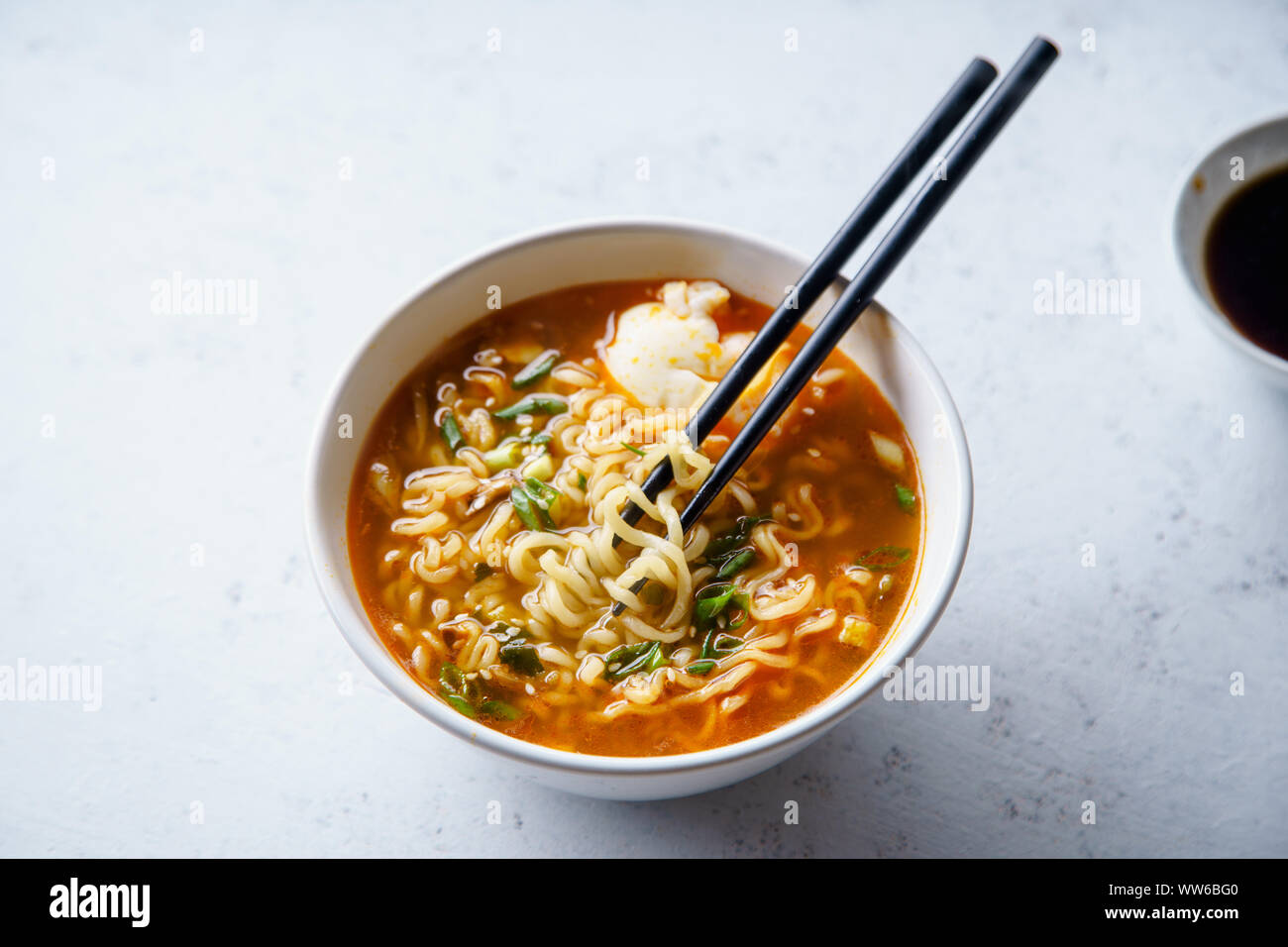 Easy japanese ramen with noodles, pork broth, egg and leek in white