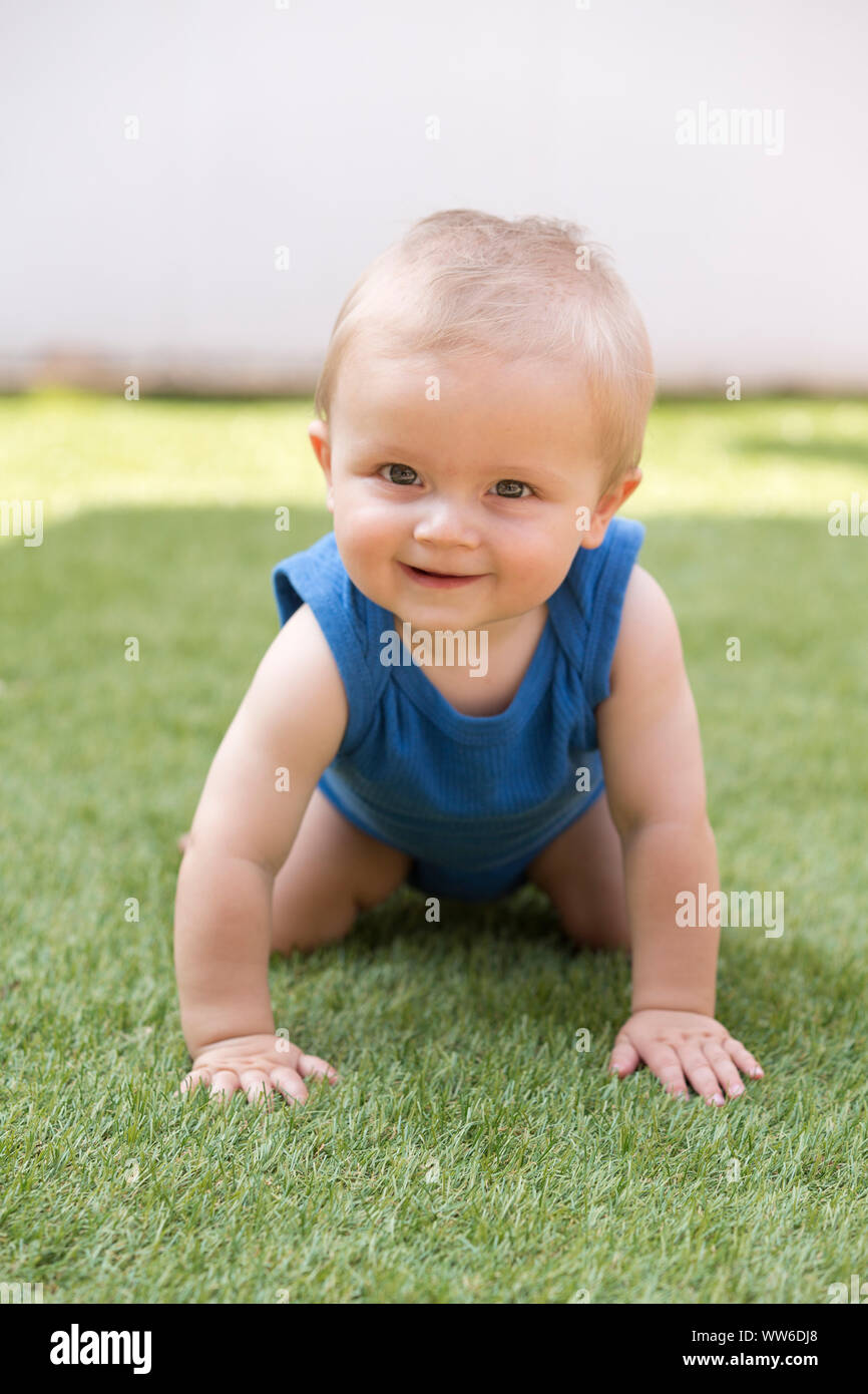 Baby crawls in the grass, portrait Stock Photo