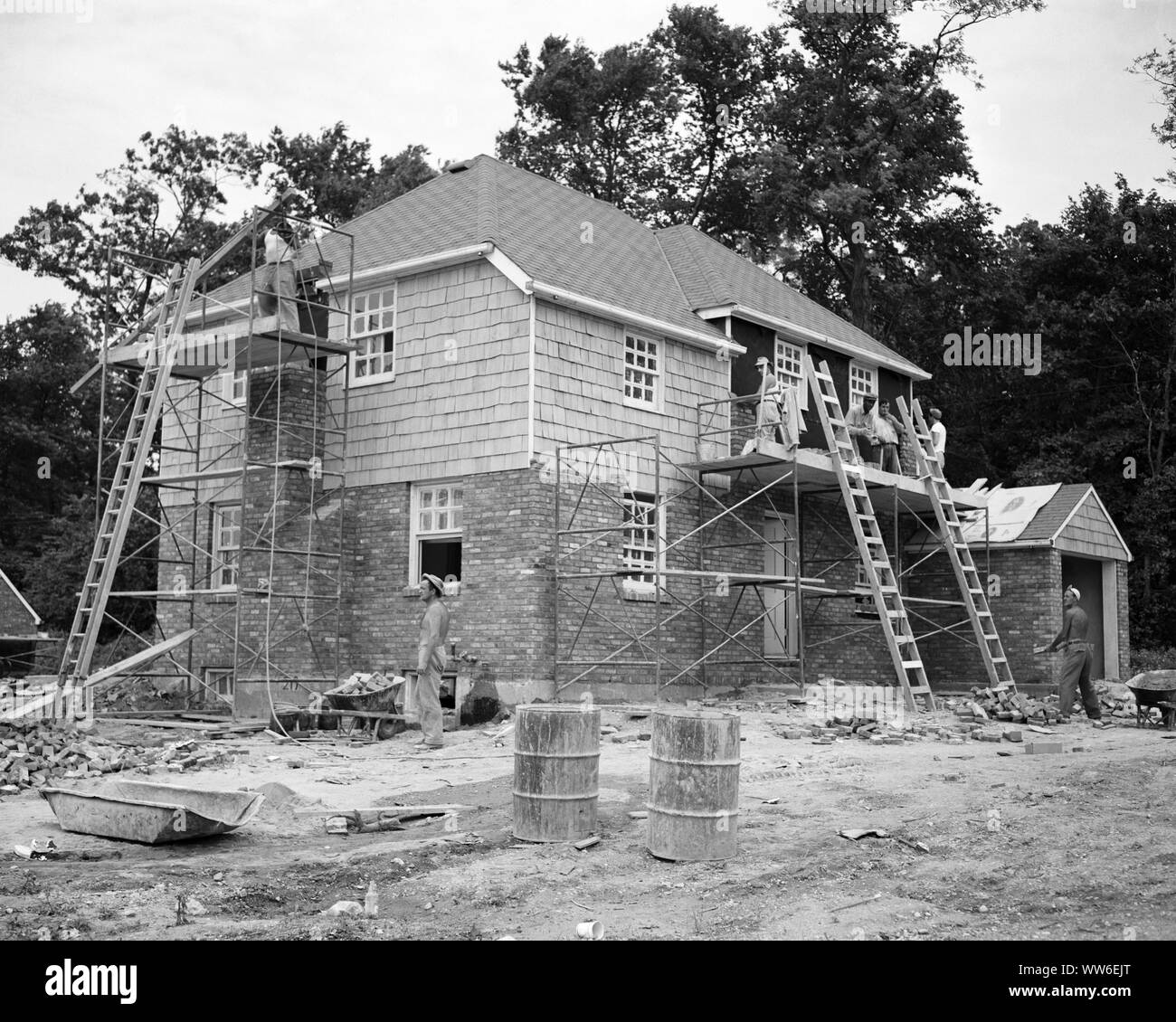 1940s 1950s HALF DOZEN ANONYMOUS WORKERS BUILDING LEVITTOWN SUBURBAN HOME $22,500 MODEL ROSLYN HEIGHTS LONG ISLAND NEW YORK USA - b3753 PRC001 HARS VISION SKILL DREAMS OCCUPATION SKILLS PROPERTY STRENGTH STRATEGY CUSTOMER SERVICE CHOICE EXTERIOR LOW ANGLE PROGRESS INNOVATION POSTWAR WORLD WAR II 1947 OCCUPATIONS REAL ESTATE LONG ISLAND CONCEPTUAL LEVITTOWN NEW YORK STRUCTURES IMAGINATION NORTH SHORE STYLISH WORLD WAR 2 EDIFICE ANONYMOUS HAMLET BOOM CREATIVITY HALF DOZEN IDEAS MID-ADULT MID-ADULT MAN SOLUTIONS BLACK AND WHITE OLD FASHIONED Stock Photo