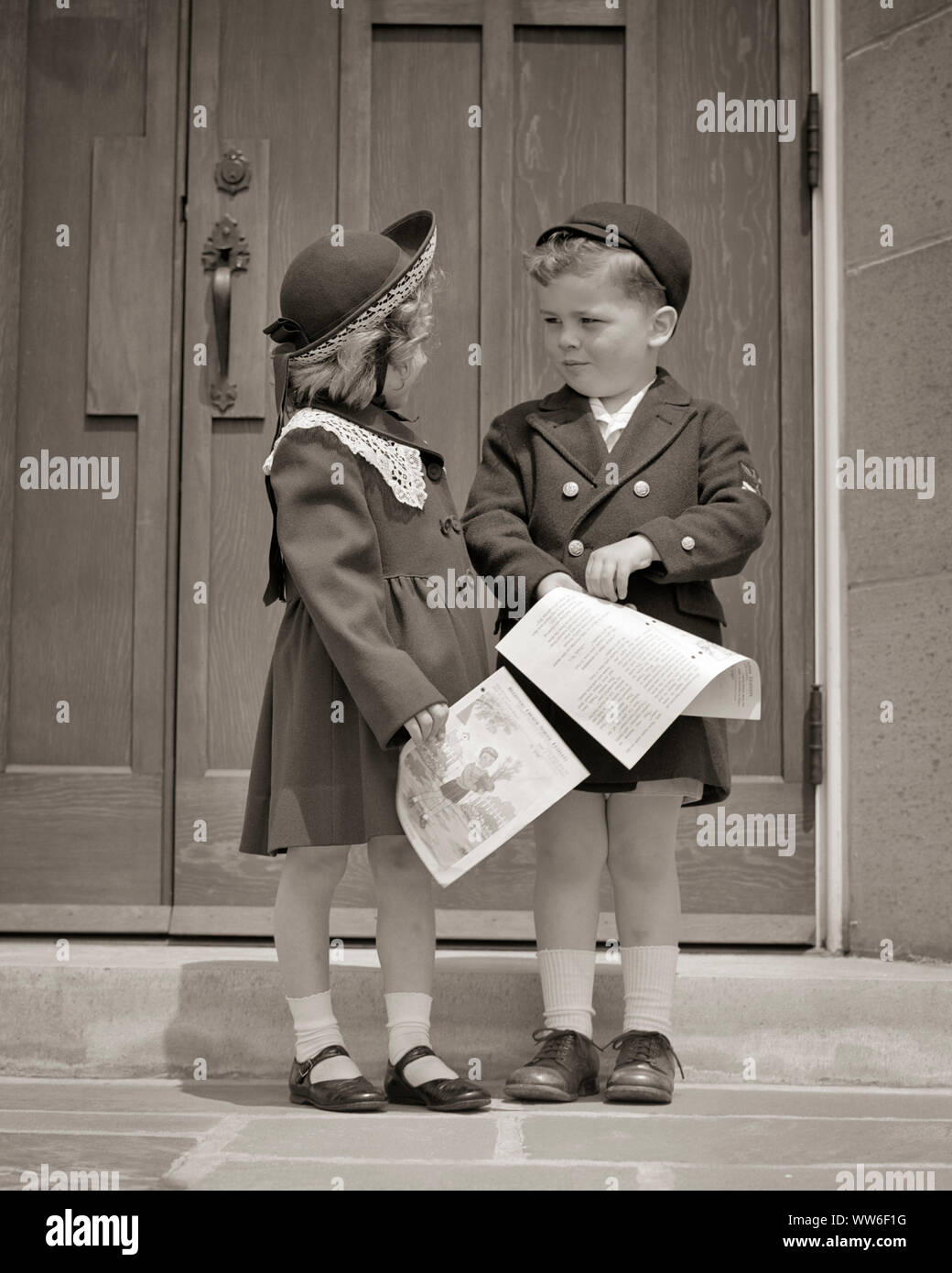 1950s BOY AND GIRL WEARING SUNDAY BEST CLOTHES COATS HATS STANDING IN FRONT OF CHURCH DOOR HOLDING SUNDAY SCHOOL PAPERS - c3505 HAR001 HARS SUNDAY BROTHERS RURAL COATS COPY SPACE FRIENDSHIP FULL-LENGTH INSPIRATION MALES SIBLINGS SPIRITUALITY SISTERS B&W SADNESS AND NETWORKING SIBLING CONNECTION STYLISH SUNDAY BEST IN FRONT OF DRESSED UP COOPERATION JUVENILES TOGETHERNESS BLACK AND WHITE CAUCASIAN ETHNICITY HAR001 OLD FASHIONED SUNDAY SCHOOL Stock Photo