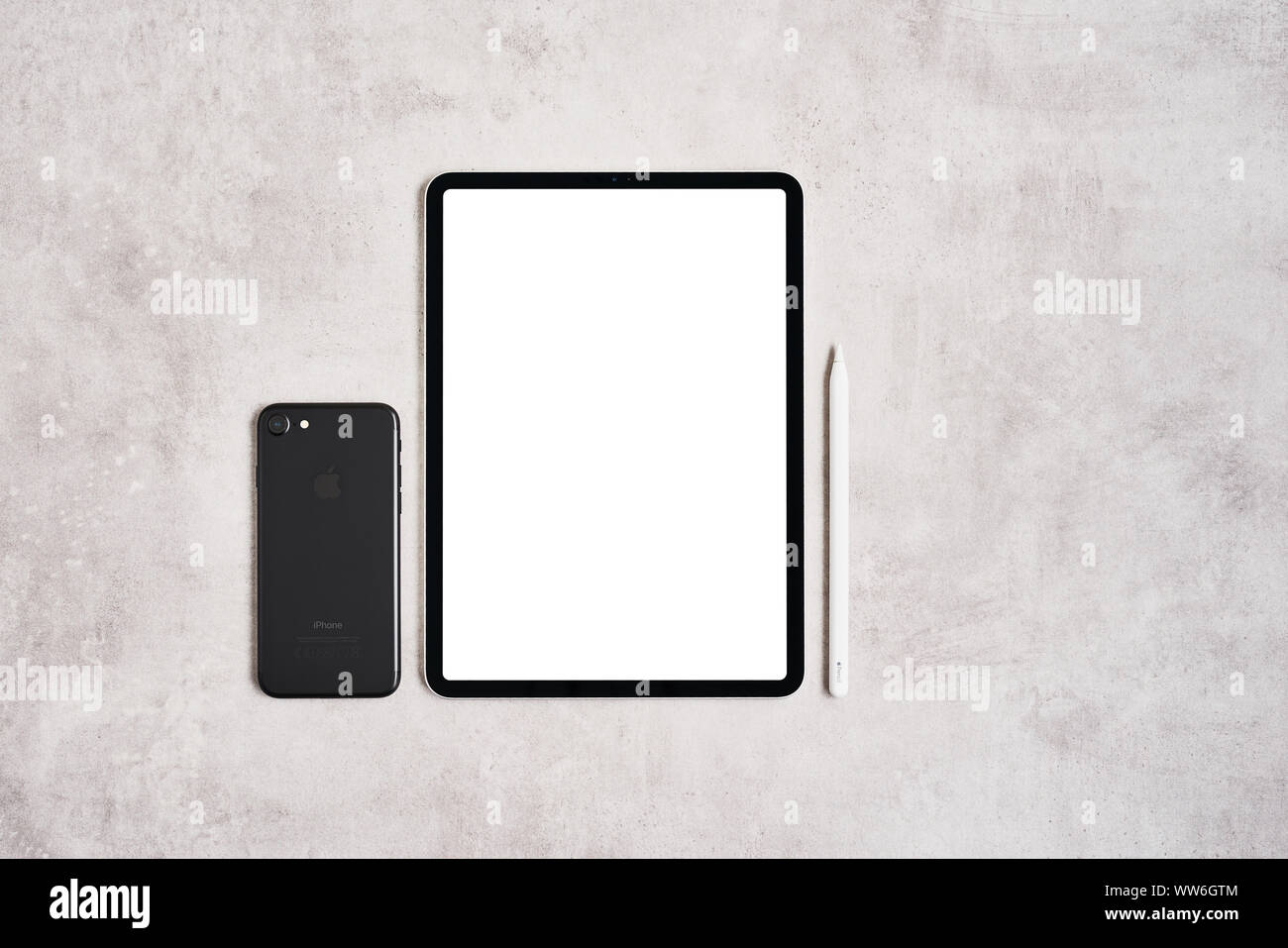 ZAGREB, CROATIA - SEPTEMBER 10, 2019: Top view of Apple iPad Pro, pencil and iPhone on grey concrete background. Stock Photo