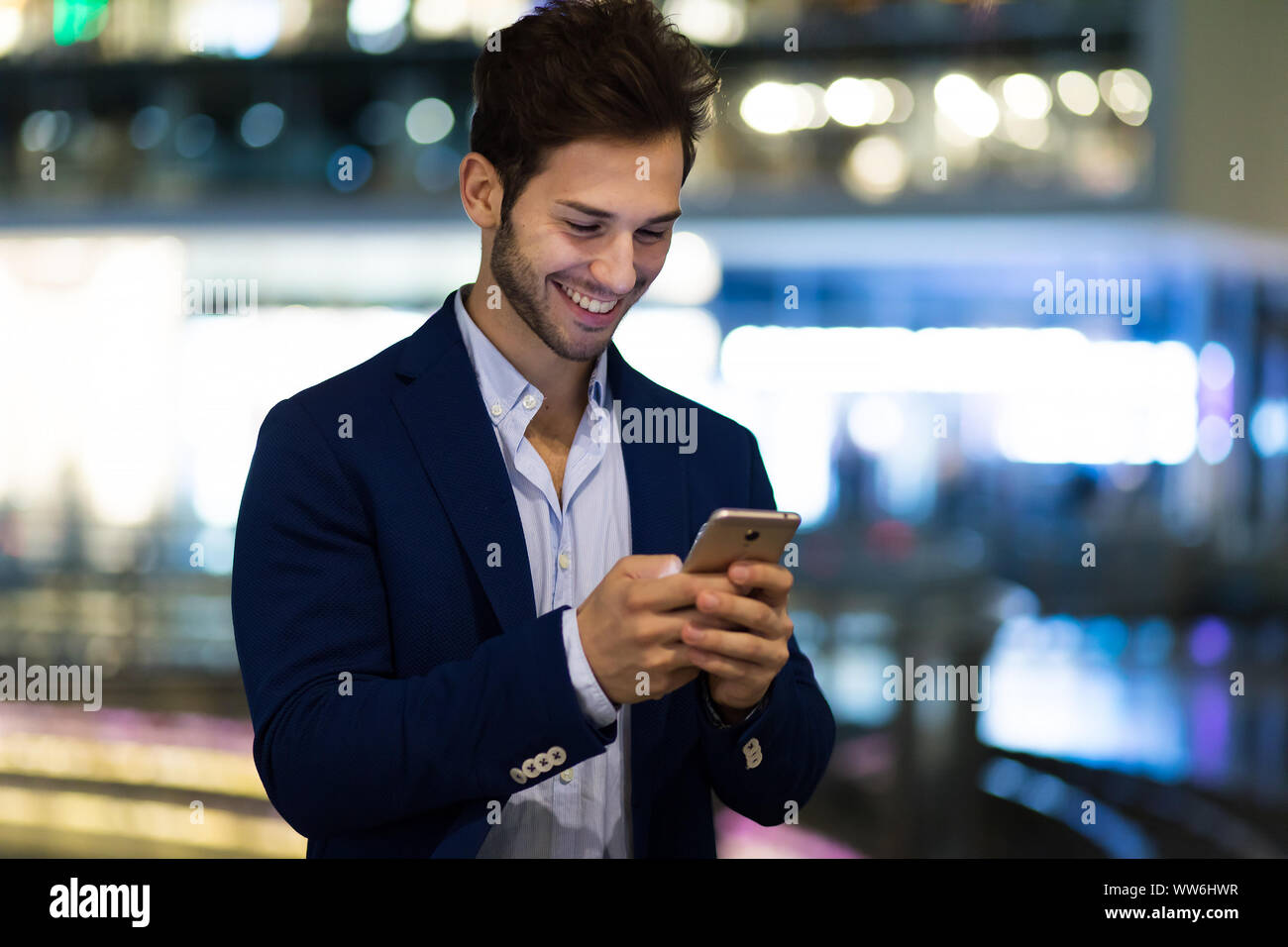 Young manager using his smartphone outdoor at night in the city Stock ...