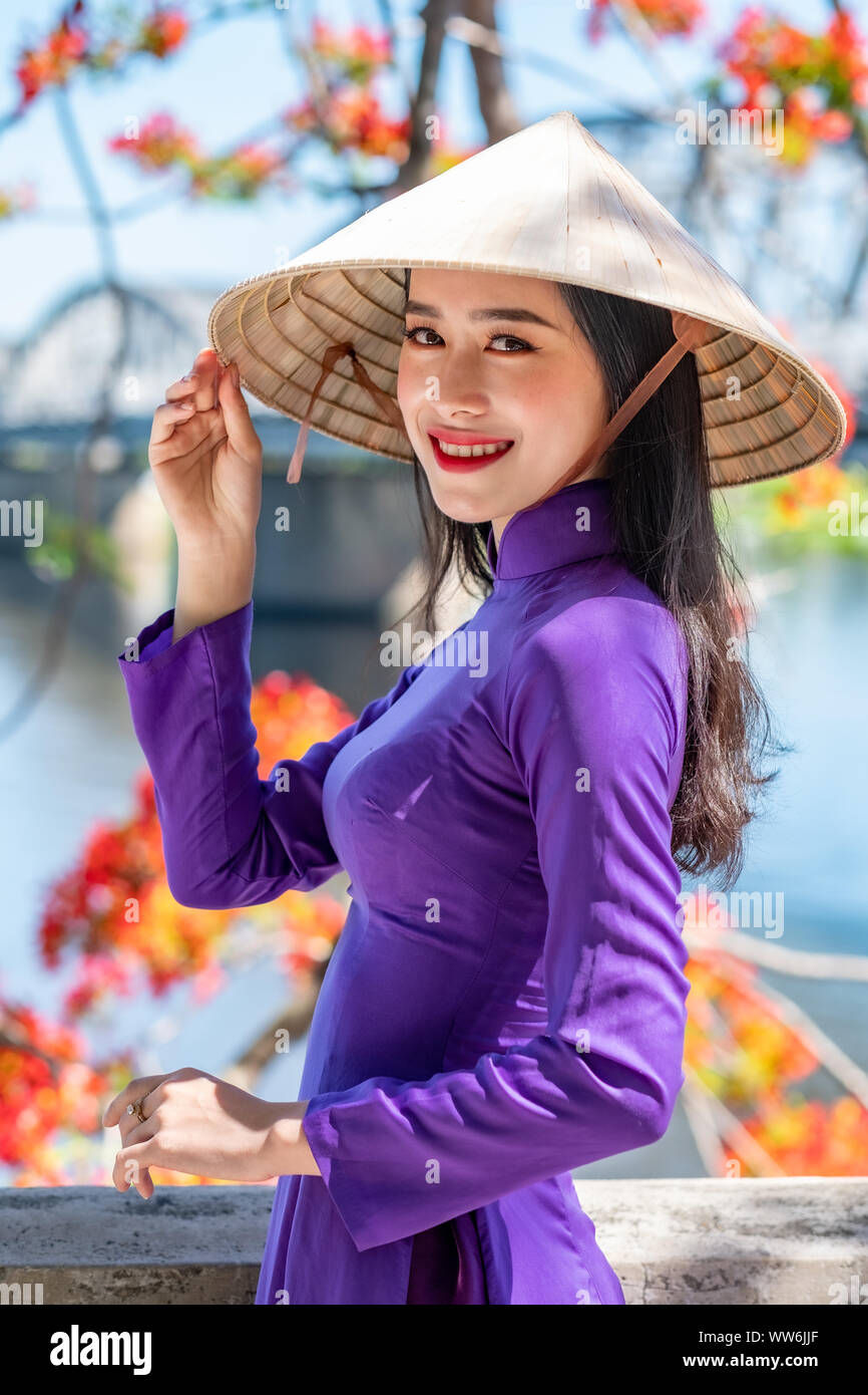 Portrait of a beautiful woman wearing traditional clothing and conical hat, Vietnam Stock Photo