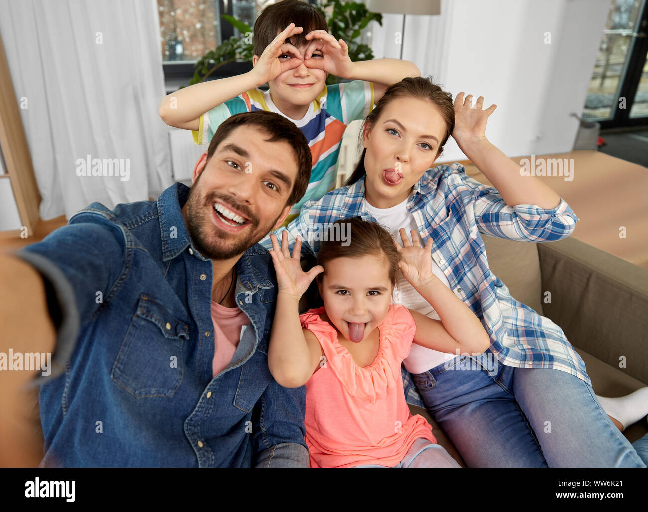 family taking selfie and making faces at home Stock Photo
