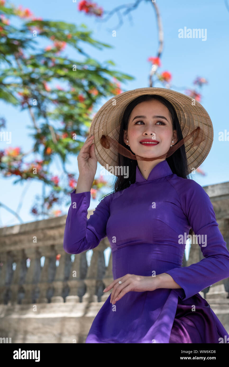 Portrait of a beautiful woman wearing a traditional costume and conical hat, Vietnam Stock Photo