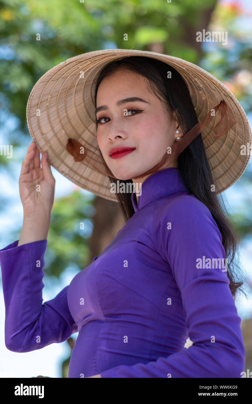 Portrait of a beautiful woman wearing a traditional costume and conical hat, Vietnam Stock Photo