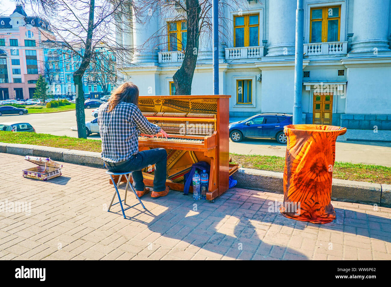 KIEV, UKRAINE - APRIL 13, 2018: The street musician entertains people in park on Saint Vladimir's Hill, playing piano, on April 13 in Kiev. Stock Photo