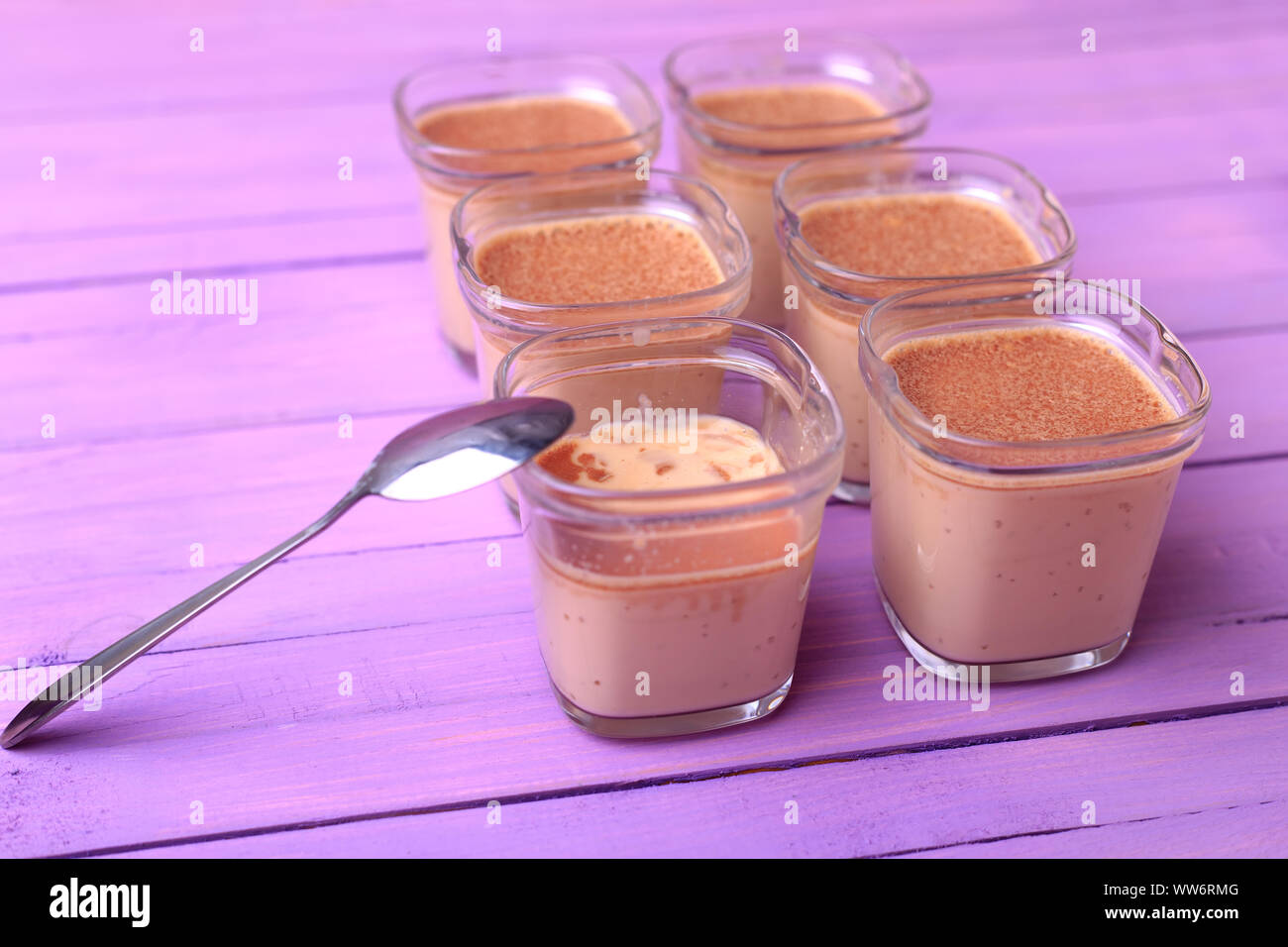 Six portions of chocolate milk dessert are on a wooden table of purple Stock Photo Alamy