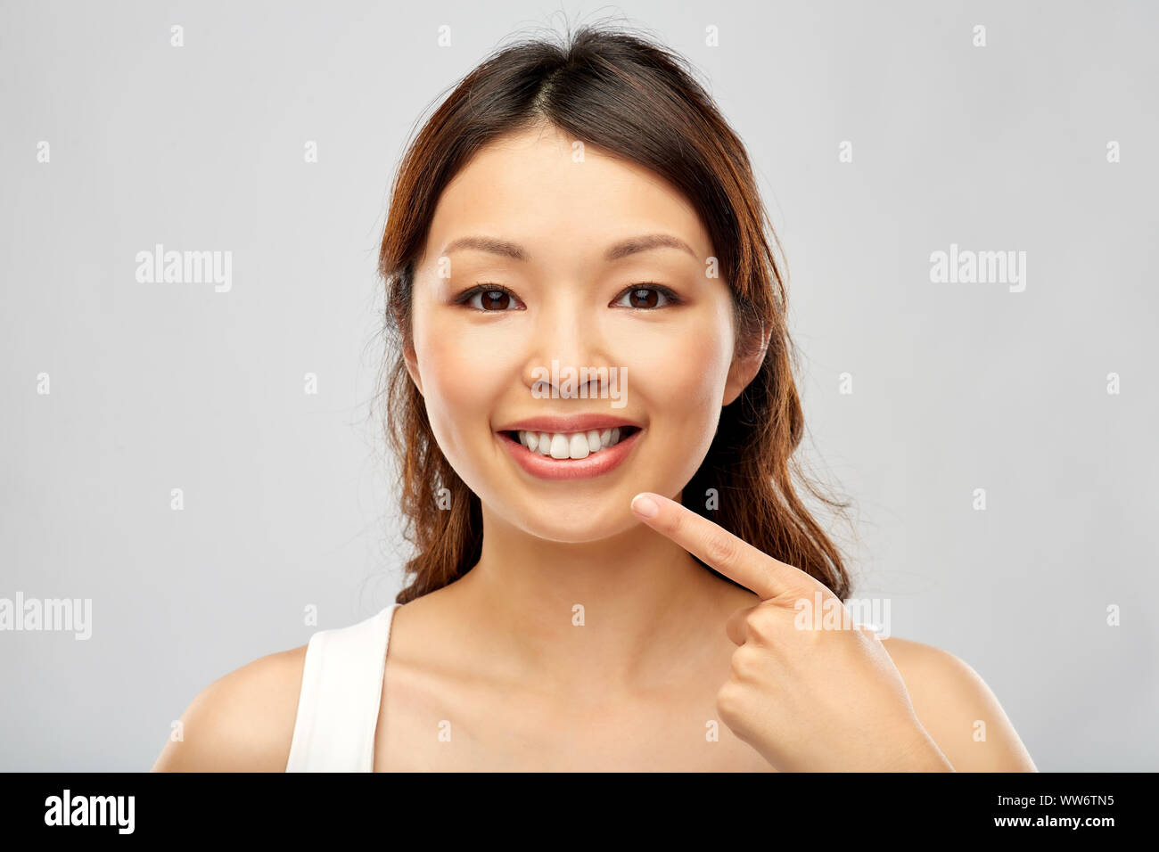 happy smiling young asian woman touching her face Stock Photo - Alamy
