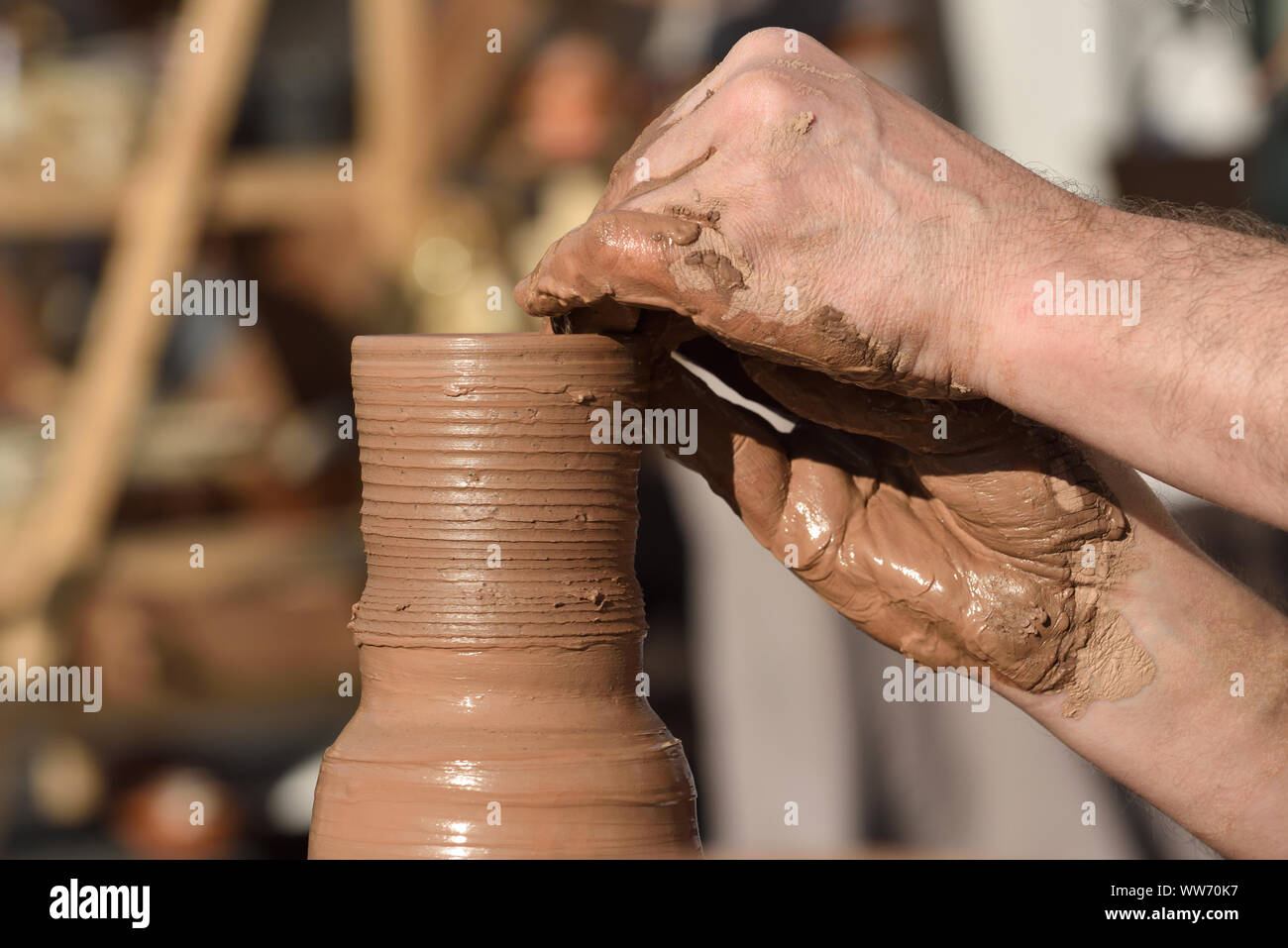 Pottery male ceramist creates a hand made clay product. Process of rotation of potters wheel, hands of ceramist. Stock Photo