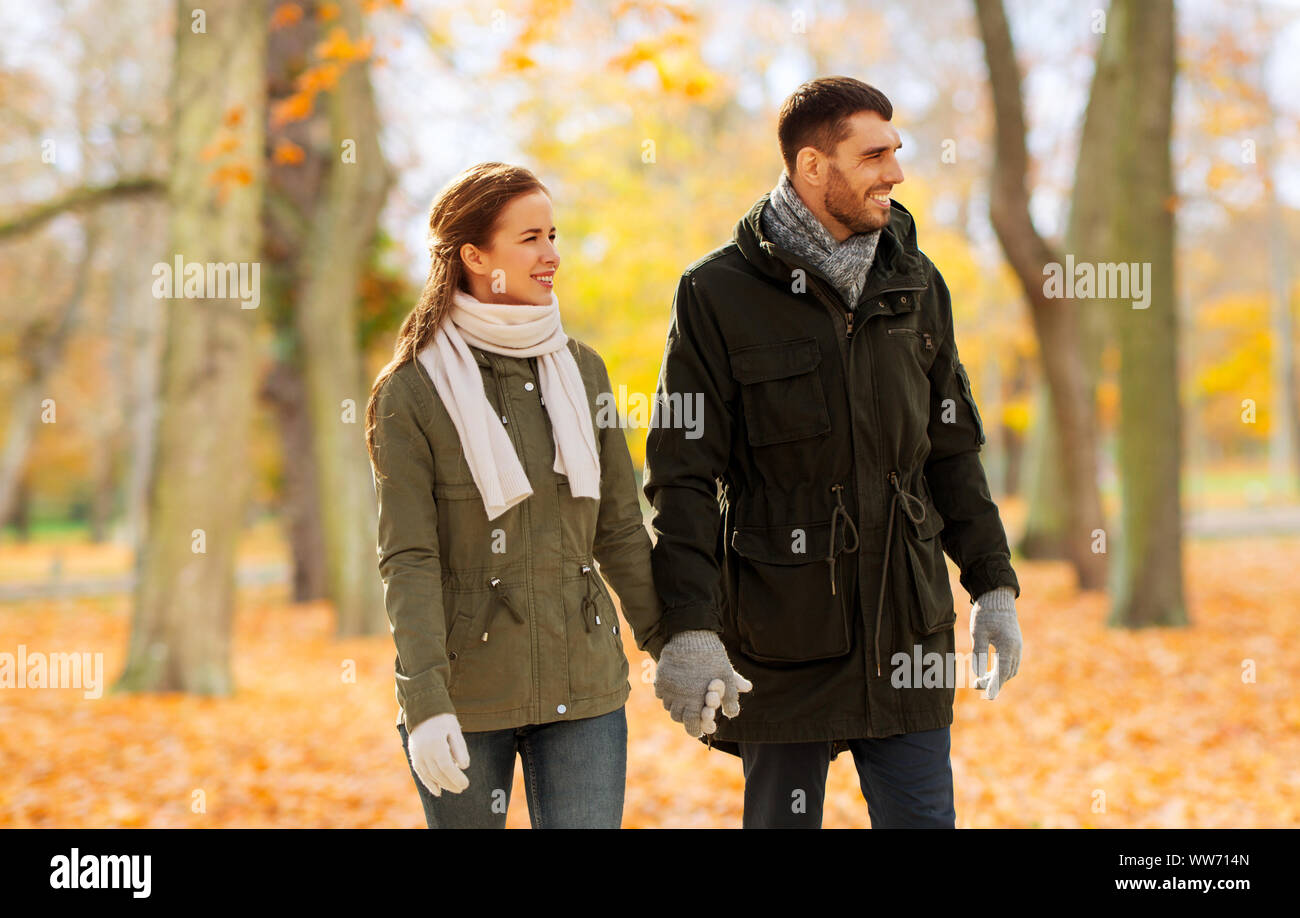 couple holding hands and walking along autumn park Stock Photo - Alamy