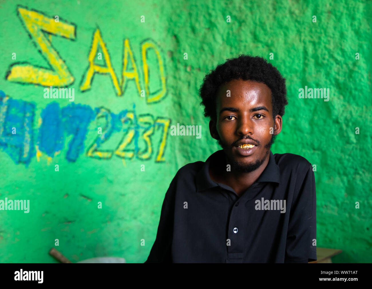 Young somali man in a shop with green walls, Sahil region, Berbera, Somaliland Stock Photo