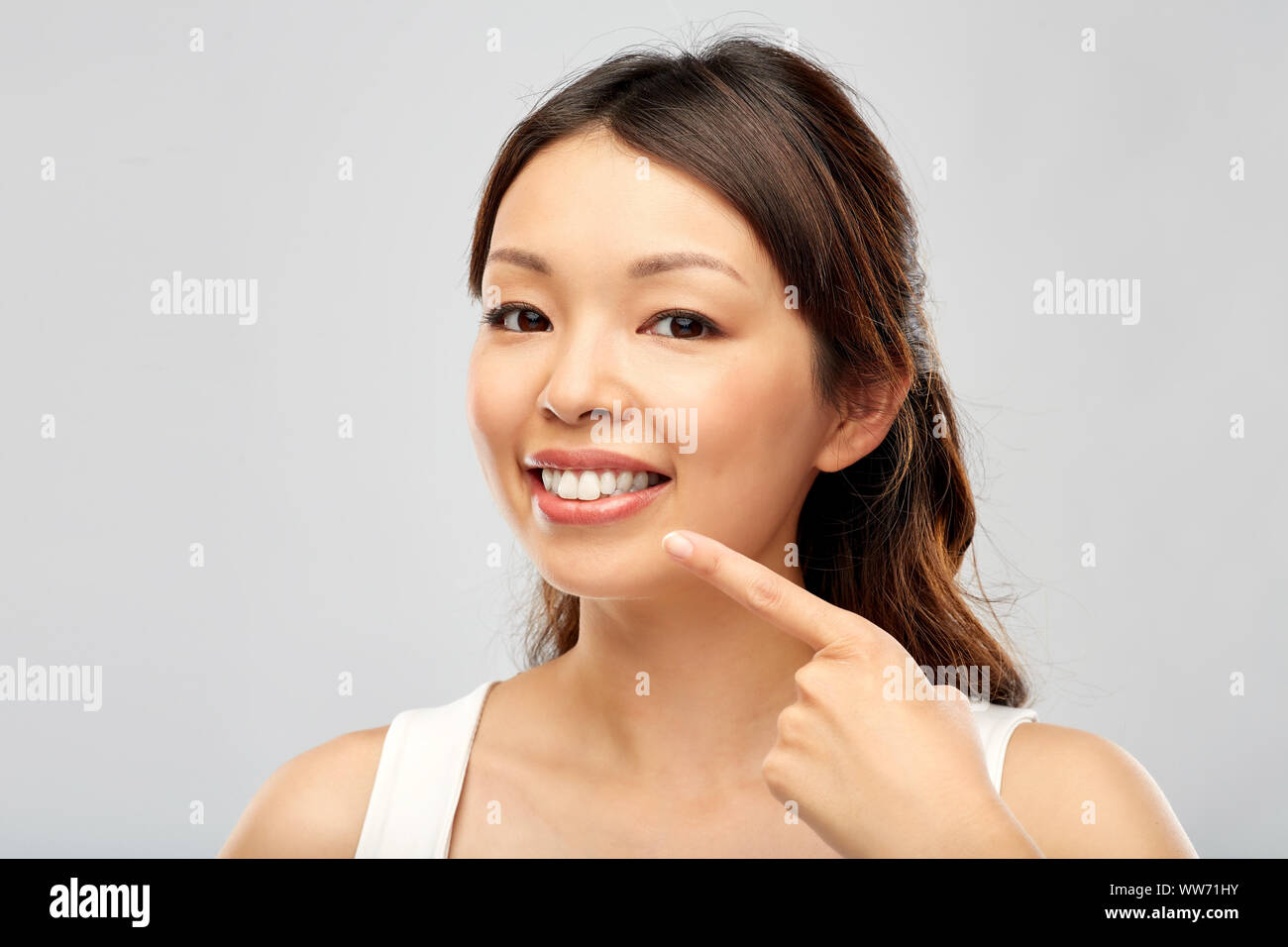 happy smiling young asian woman touching her face Stock Photo - Alamy