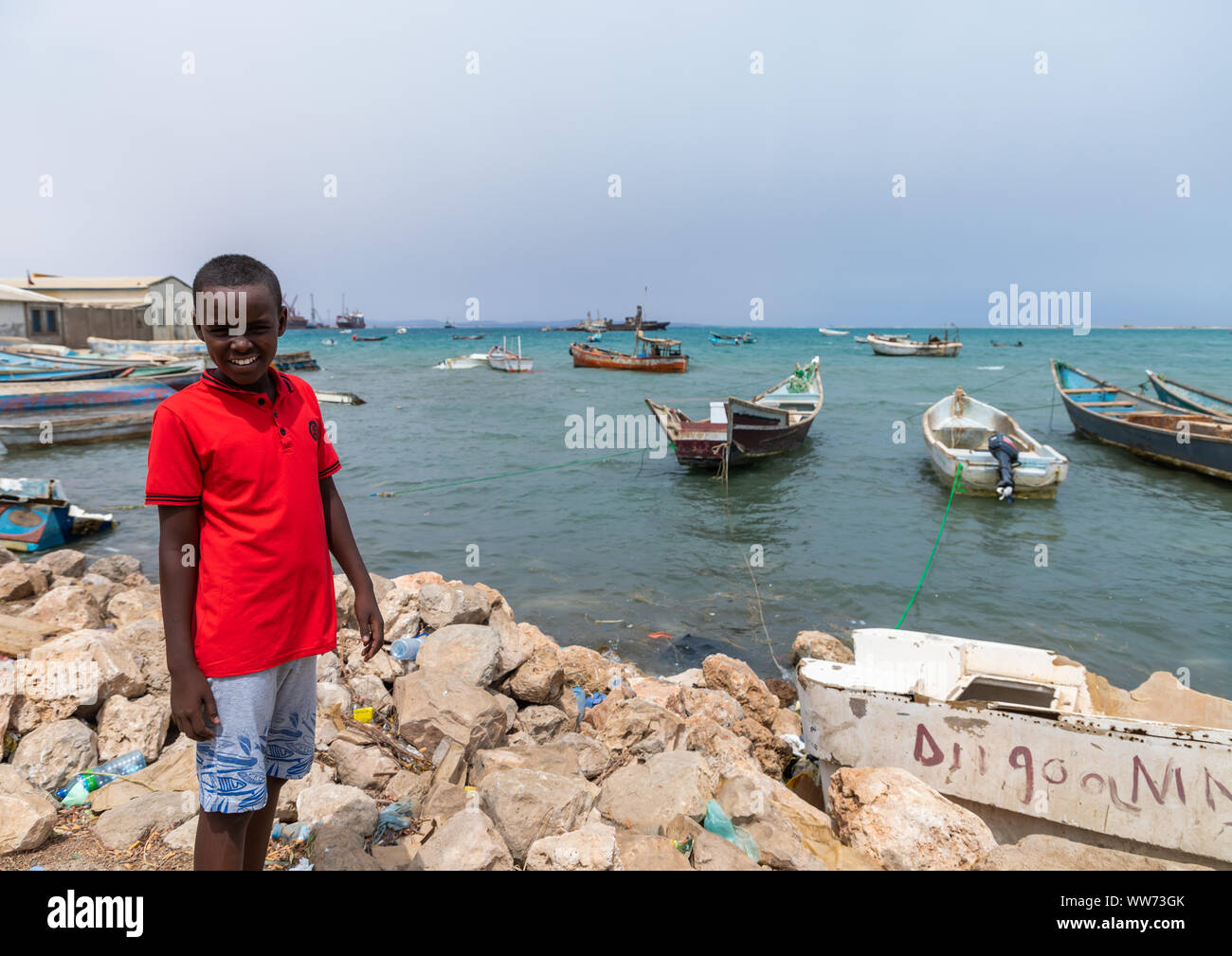 Somali boy in front of stationing boats in the port, Sahil region, Berbera, Somaliland Stock Photo