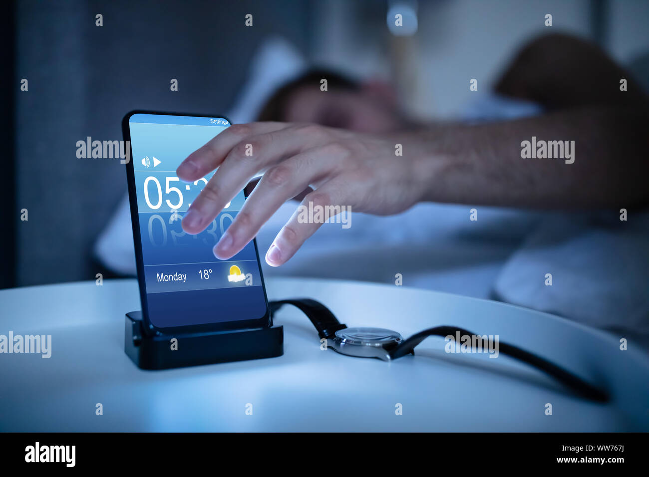 Man Waking Up With Alarm On Mobile Phone At Home Stock Photo Alamy