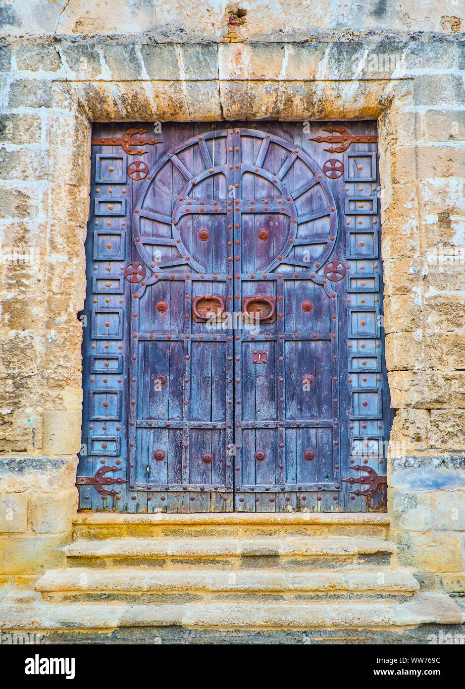A typical Arab wooden door of a Mosque with the shape of Horseshoe arch. Stock Photo