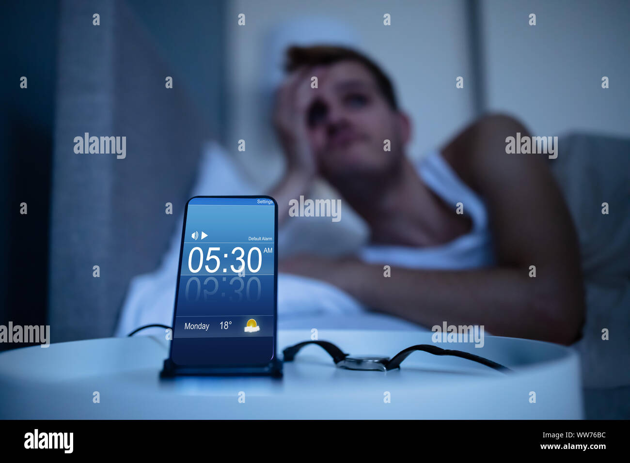 Man Waking Up With Alarm On Mobile Phone At Home Stock Photo Alamy
