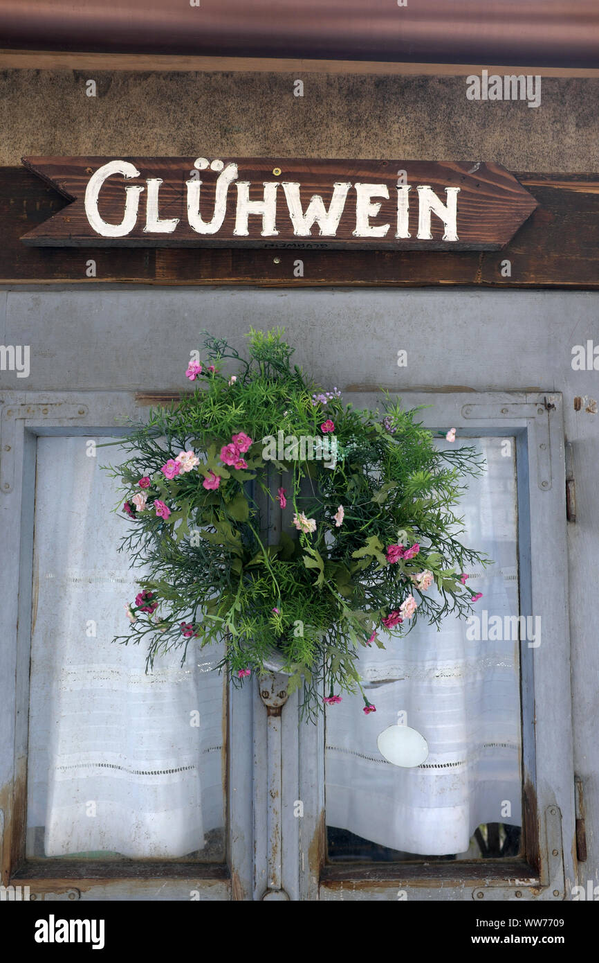 Mulled wine 'GlÃ¼hwein' sign, plastic flowers Stock Photo