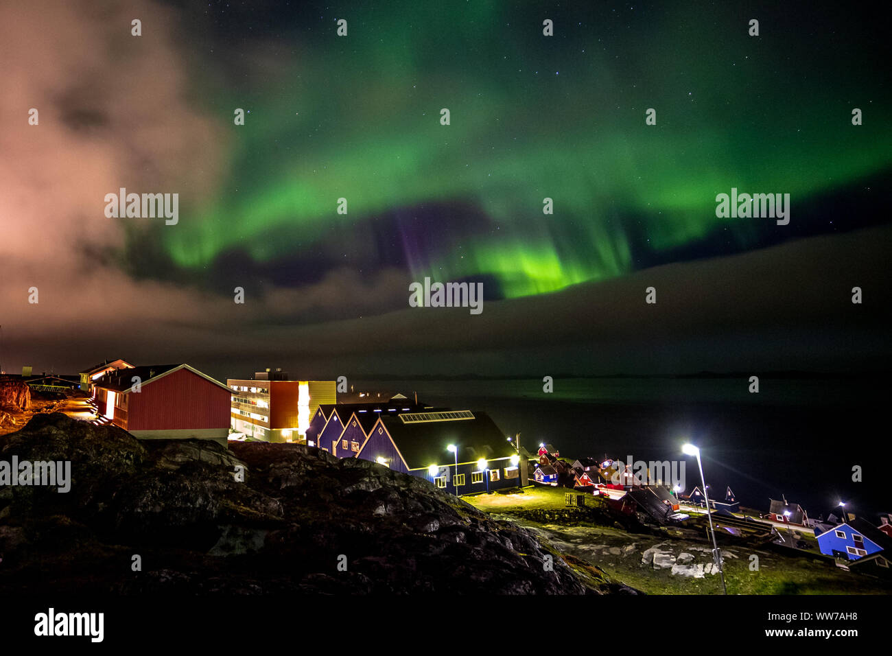 Green bright northern lights hidden by the clouds over the Inuit village at  the fjord, Nuuk city, Greenland Stock Photo - Alamy