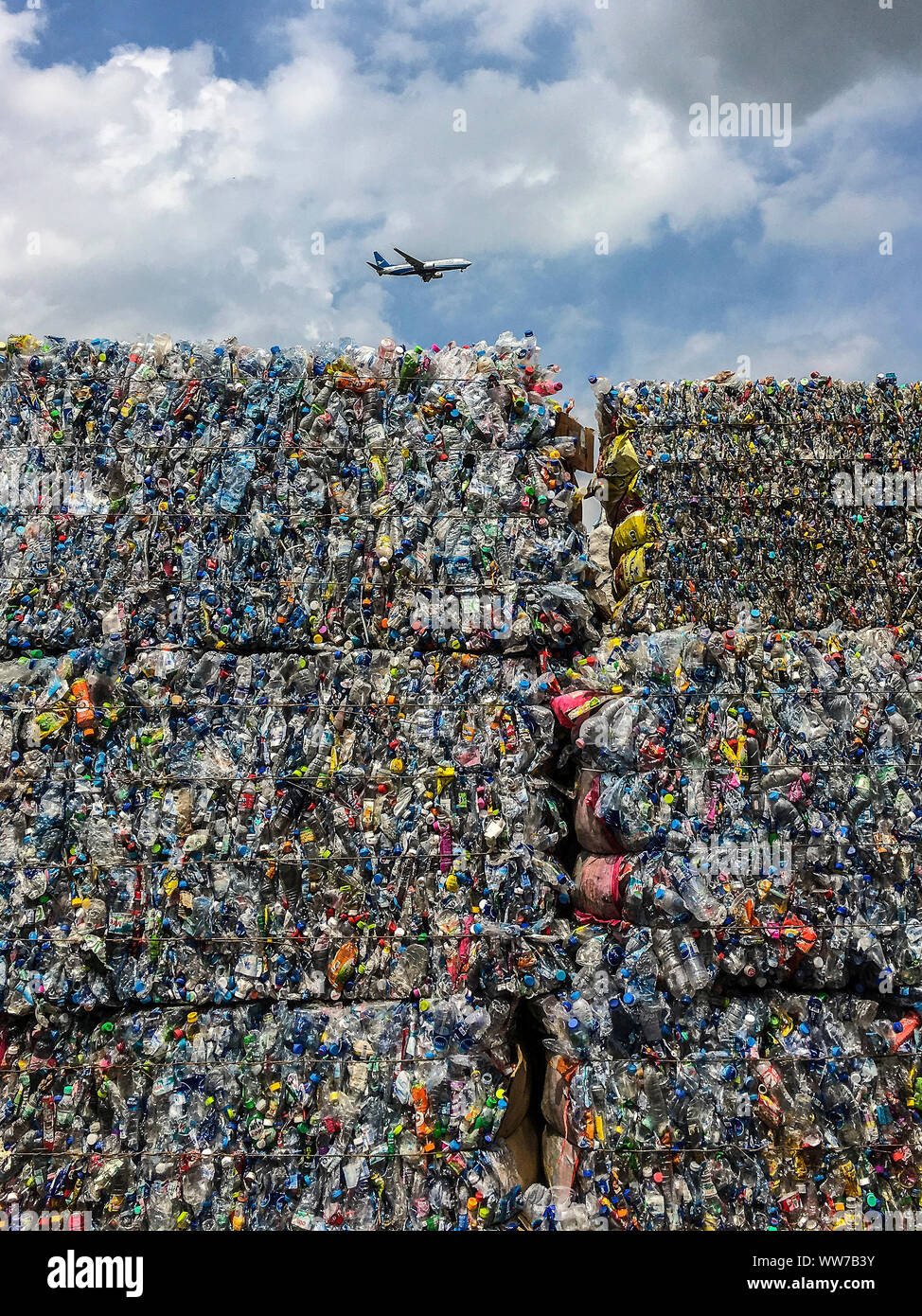 Recycling, crushed PET bottles, cloudy sky, airplane Stock Photo