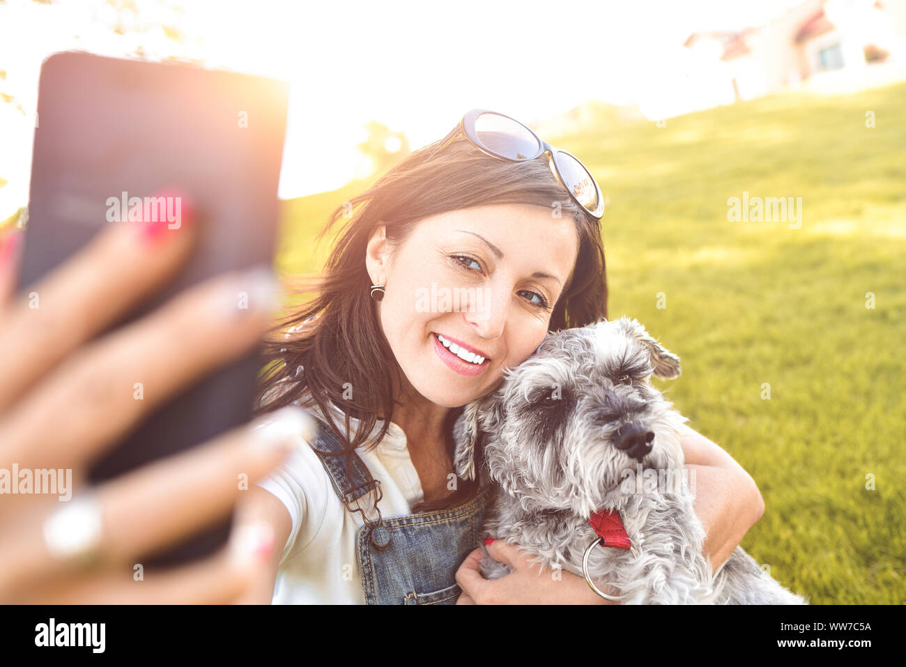 Portrait of a happy caucasian woman who hugs her beloved dog and Makes selfie with him .The concept of love for animals. best friends. Dog breed Schna Stock Photo