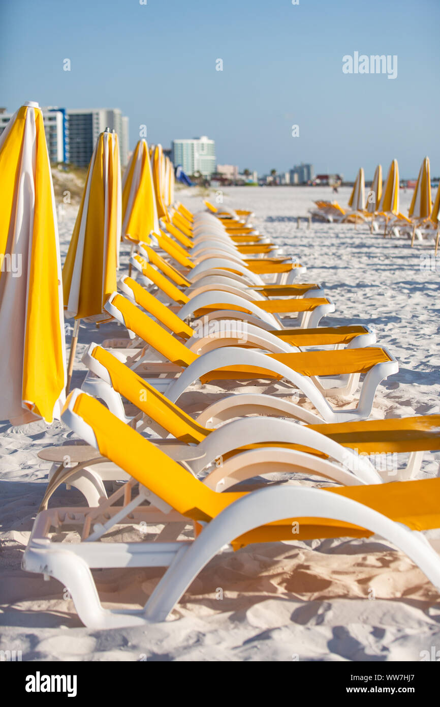 Empty white and yellow plastic beach chairs and umbrellas in Clearwater Beach, Florida, USA. Stock Photo