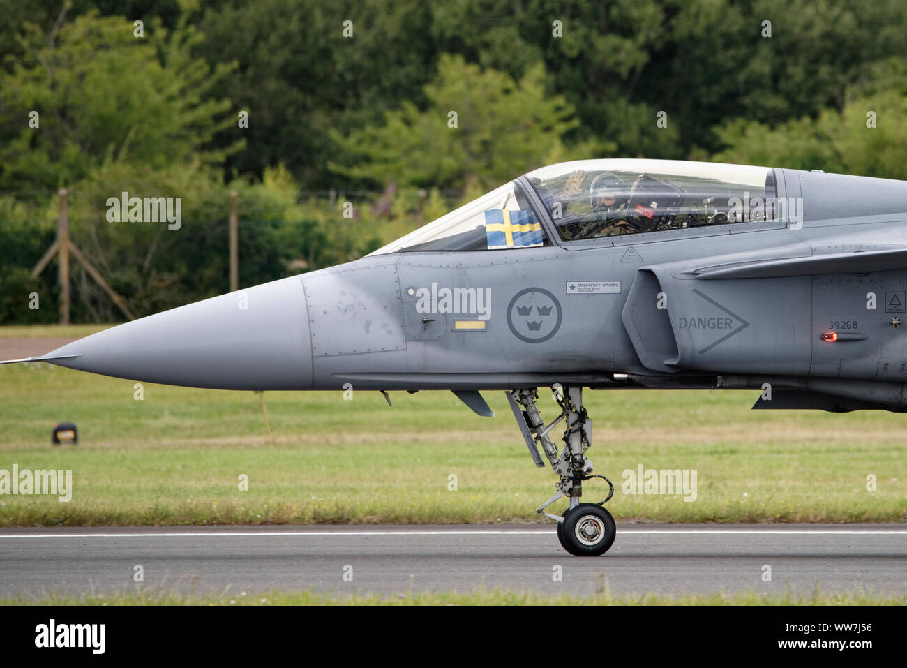 Major Peter Fallén from F7 Wing of the Swedish Air Force waves to the crowd from the cockpit of his Saab JAS 39C Gripen Multirole Fighter Jet at RIAT Stock Photo