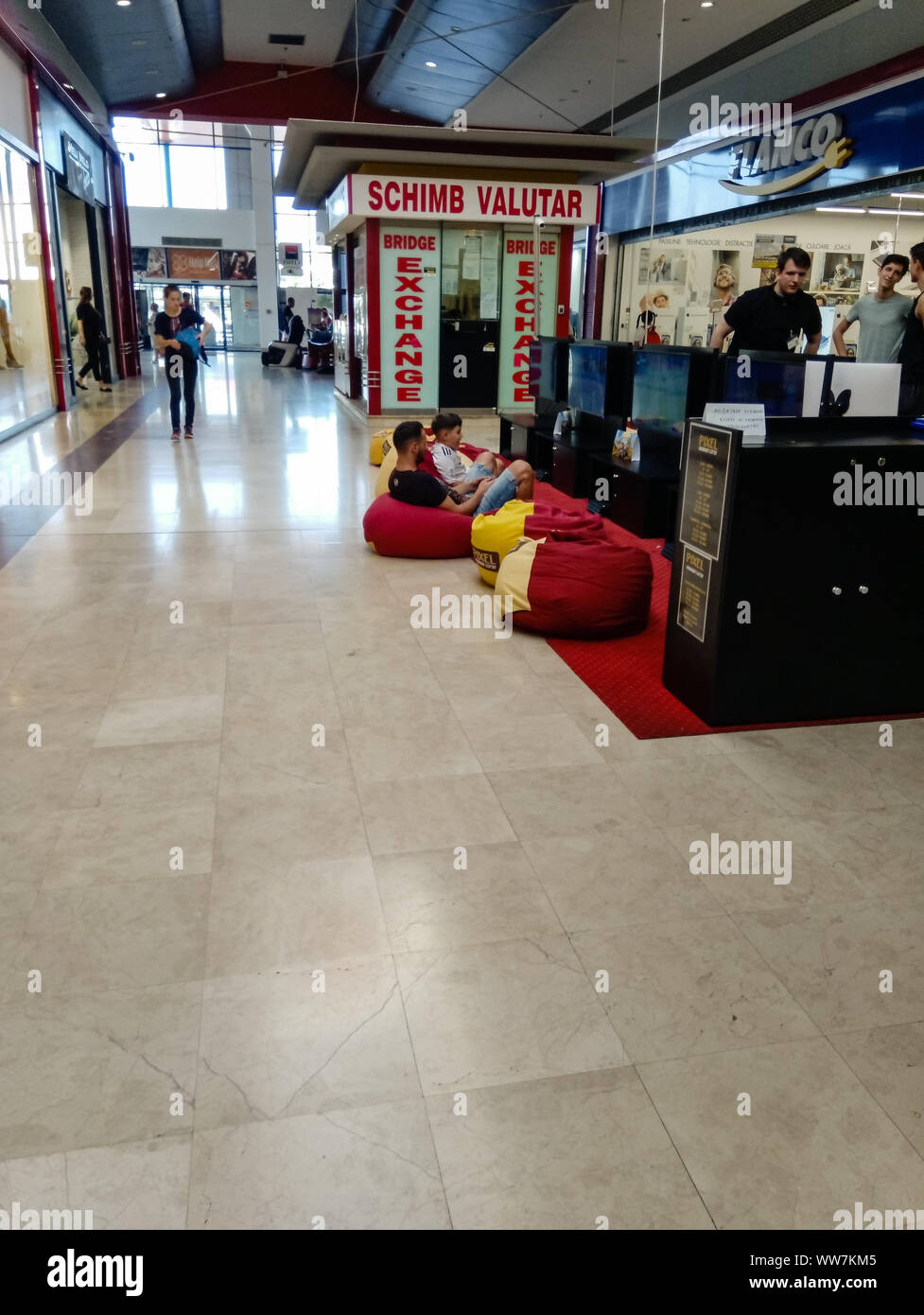 Adults And Kids Playing Video Games Inside The Shopping Store In