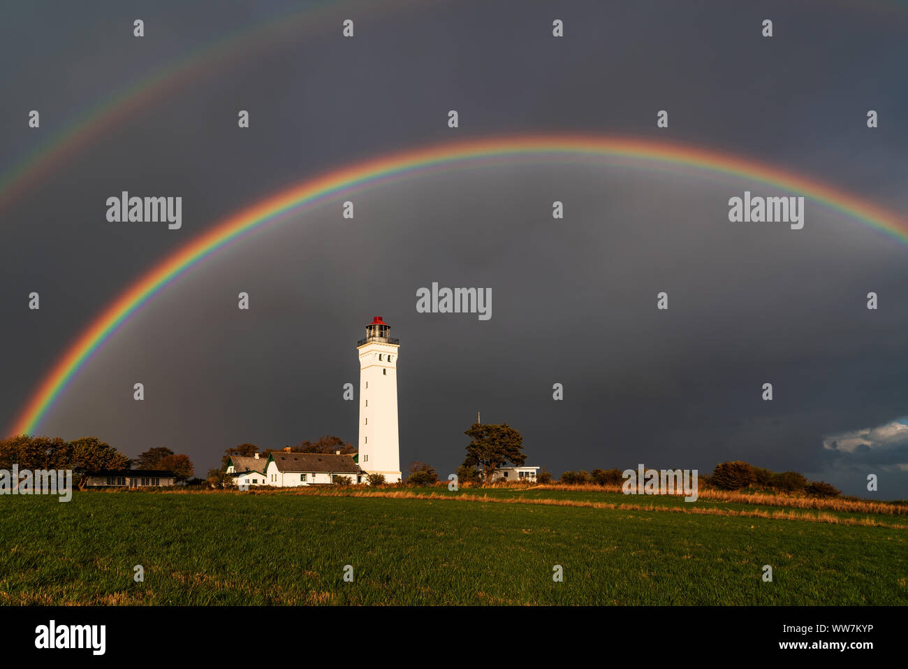 Rainbow above the lighthouse Keldsnor Fyr, island Langeland, Denmark Stock Photo