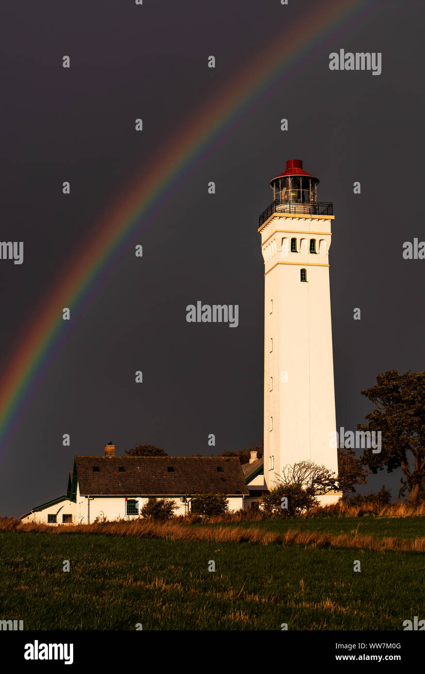 Rainbow above the lighthouse in Keldsnor, island Langeland, Denmark Stock Photo