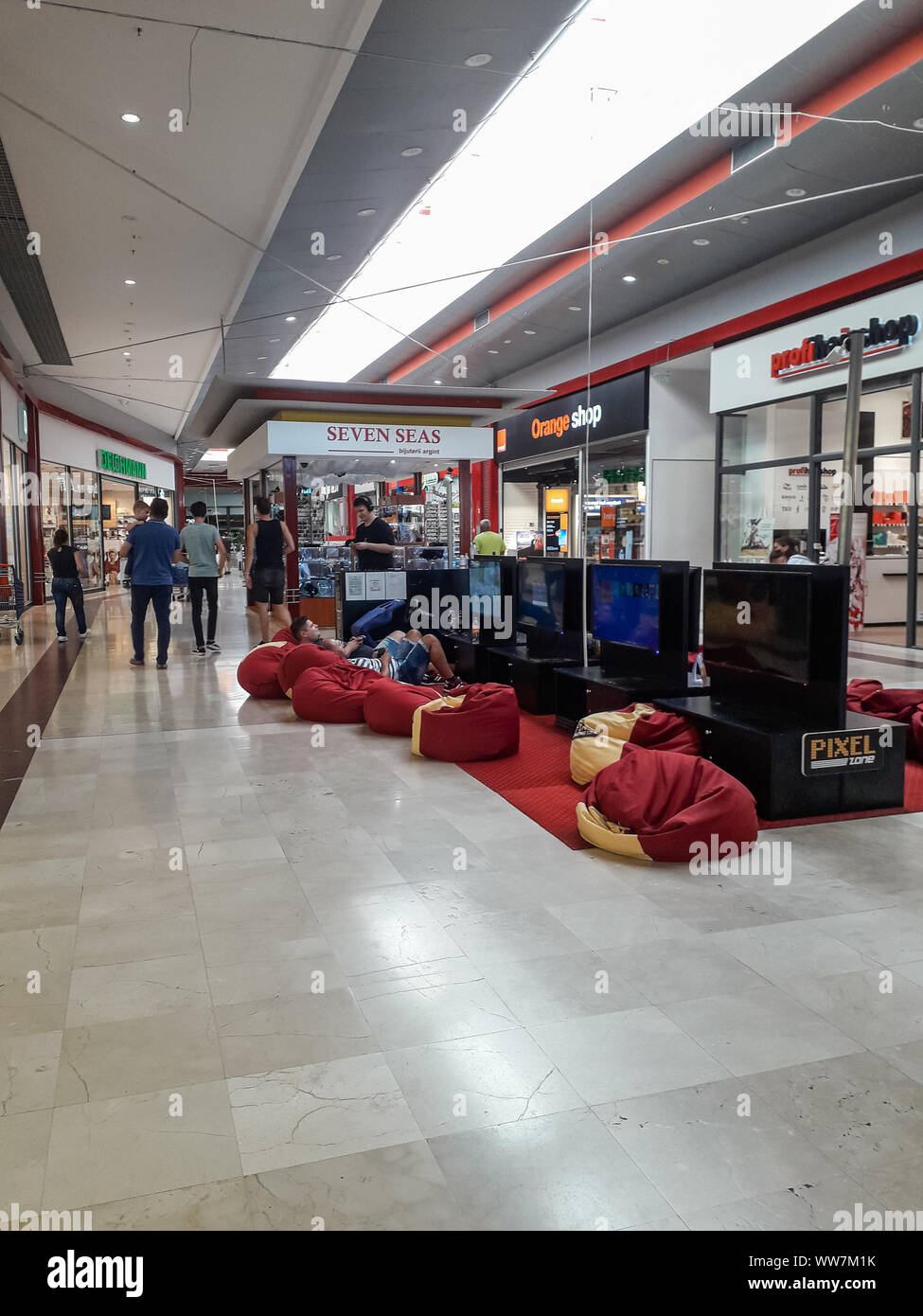 Adults And Kids Playing Video Games Inside The Shopping Store In