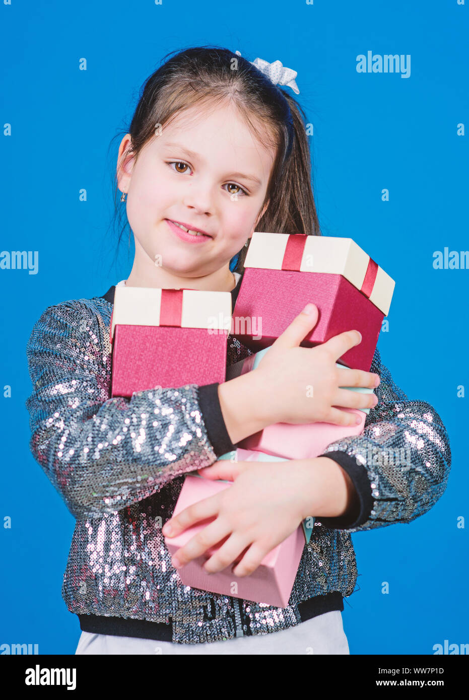 Shop for what you want. Girl with gift boxes blue background. Black friday. Shopping day. Child carry lot gift boxes. Kids fashion. Surprise gift box. Birthday wish list. Special happens every day. Stock Photo
