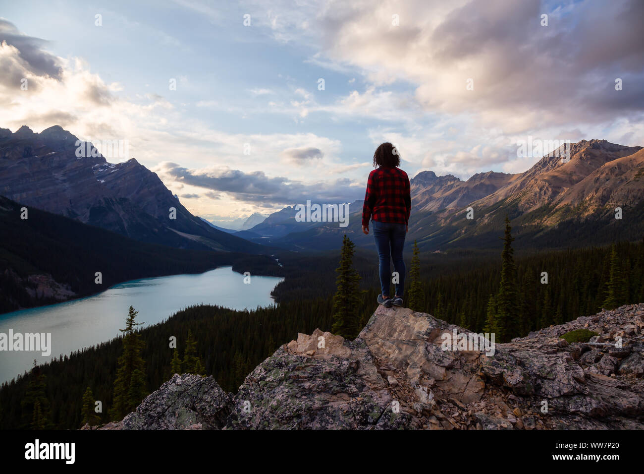 Adventurous girl standing on the edge of a cliff overlooking the ...