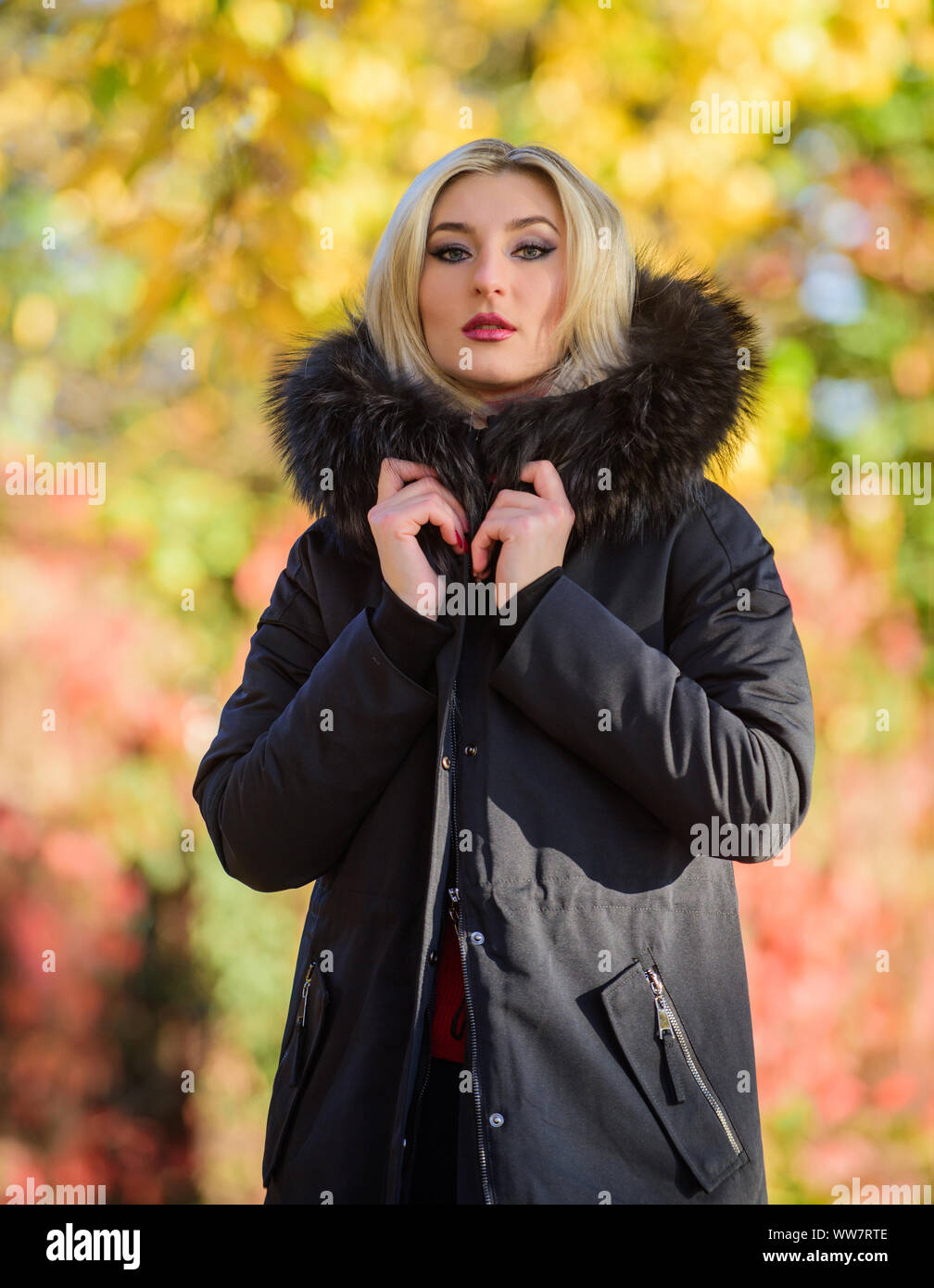 Versatile functional and stylish. Girl wear parka while walk park. Autumn  season fashion concept. Puffer jacket with hood. Woman wear black parka fur  hood. Classic parka coat has become wardrobe icon Stock