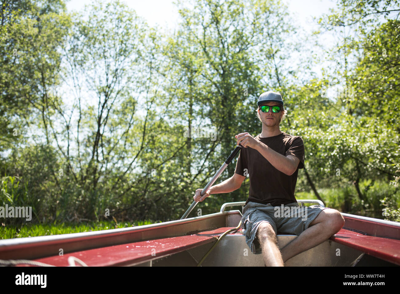 Man rowing with boat through National Park in Netherlands Stock Photo