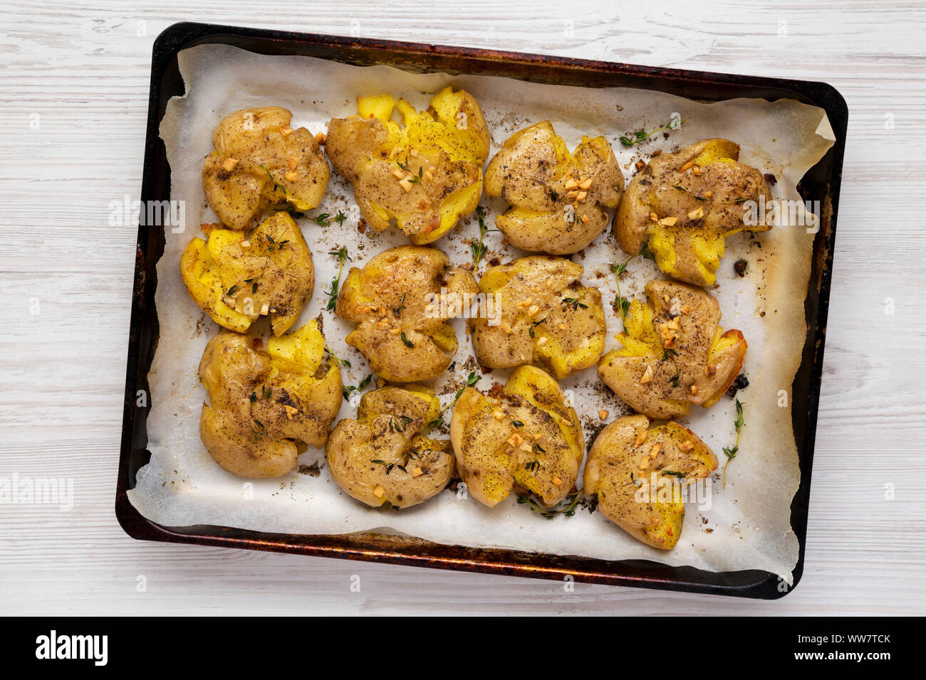 Homemade garlic thyme smashed potatoes on a tray, top view. Flat lay, overhead, from above. Close-up. Stock Photo