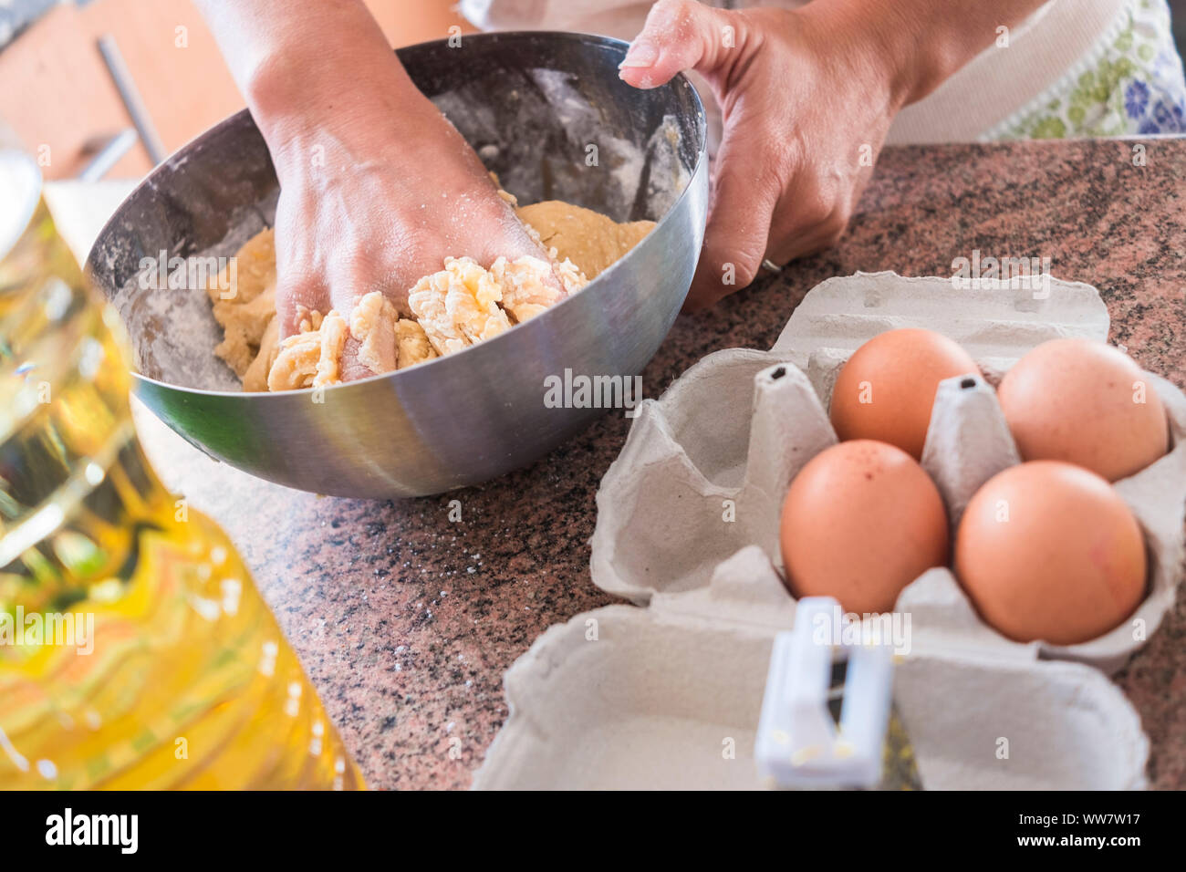 hard work in the kitchen to prepare and cook some cake. hands of a woman at home with natural food like eggs. Stock Photo