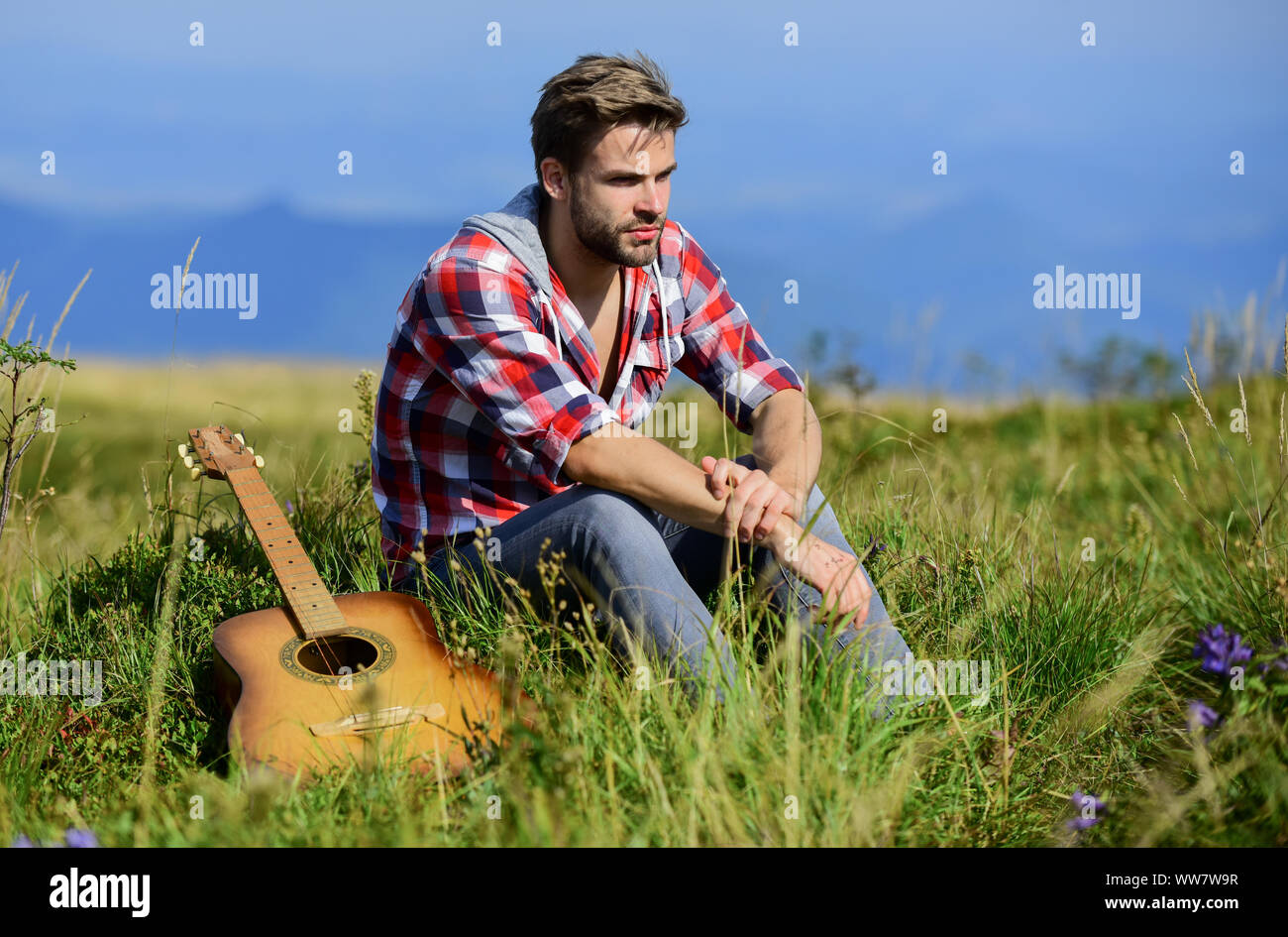 Pleasant time alone. Musician looking for inspiration. Dreamy wanderer. Wanderlust concept. Summer vacation highlands nature. Peaceful mood. Guy with guitar contemplate nature. Inspiring nature. Stock Photo