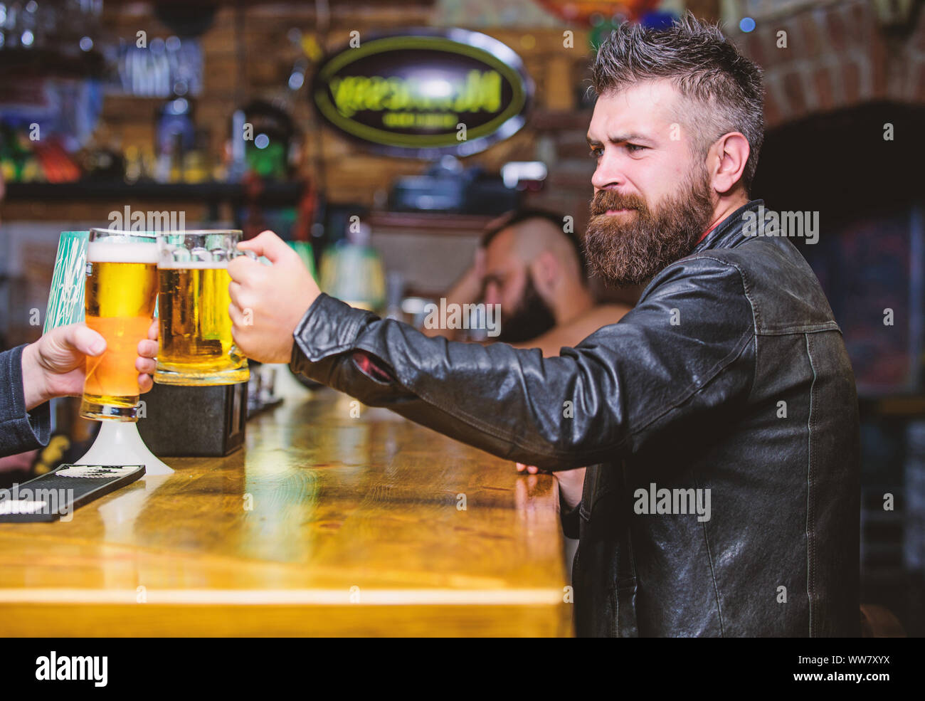 Cheers concept. Glasses with fresh lager draft beer with foam. Men hipster  hold mugs filled with cold tasty beer in bar. Friday leisure tradition. Beer  mugs at bar counter defocused background Stock