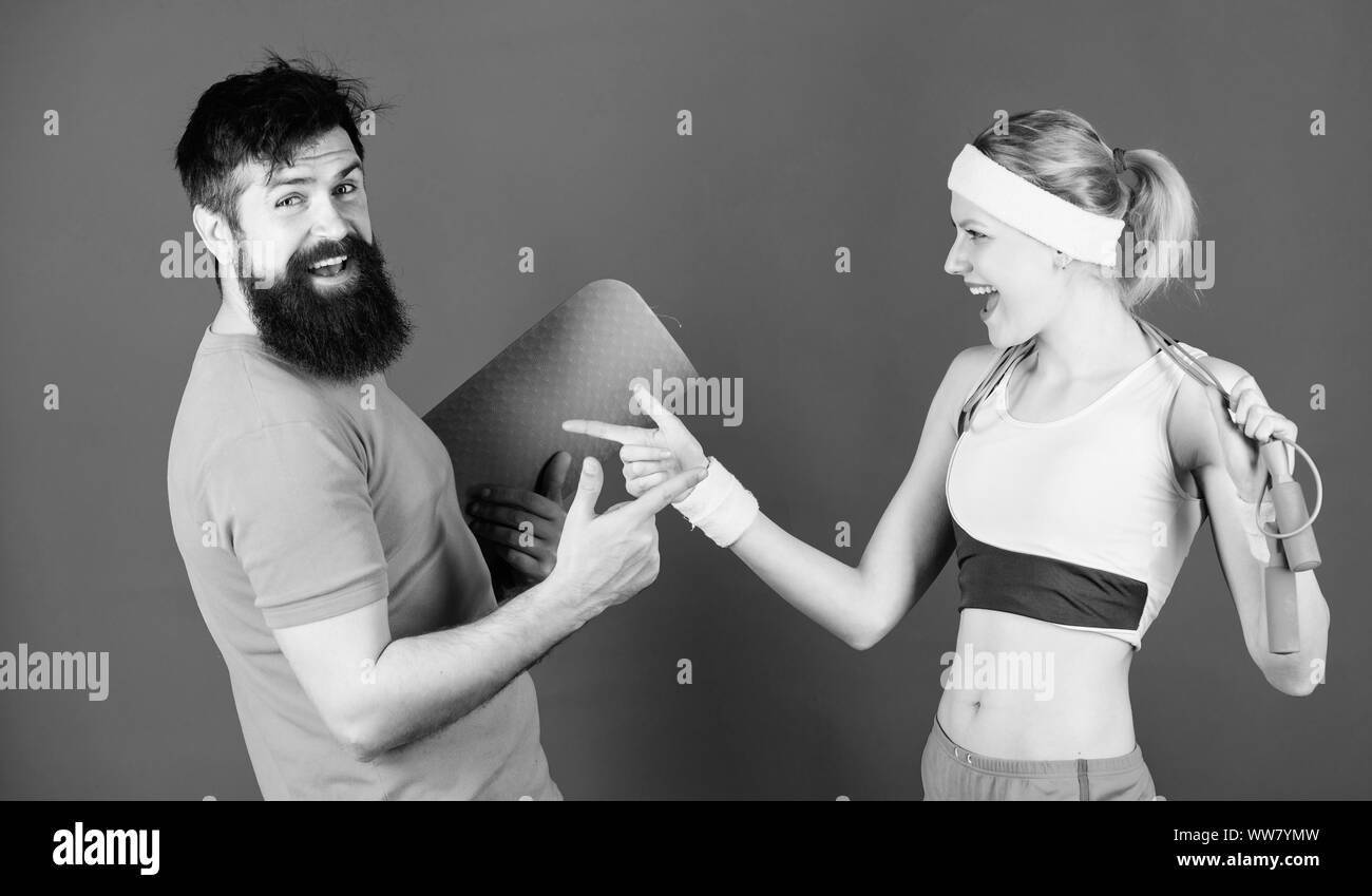 Together Everyone Achieves More. Athletic Success. Sport equipment. Strong muscles and body. Happy woman and bearded man workout in gym. Sporty couple training with fitness mat and skipping rope. Stock Photo