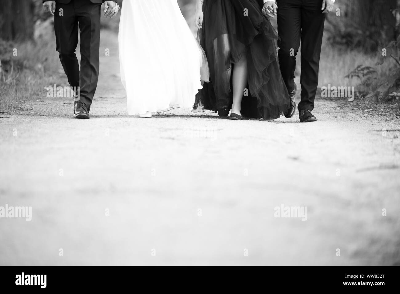 Legs of groom, bride and bridemaid and bestman. Black and white photo. Stock Photo