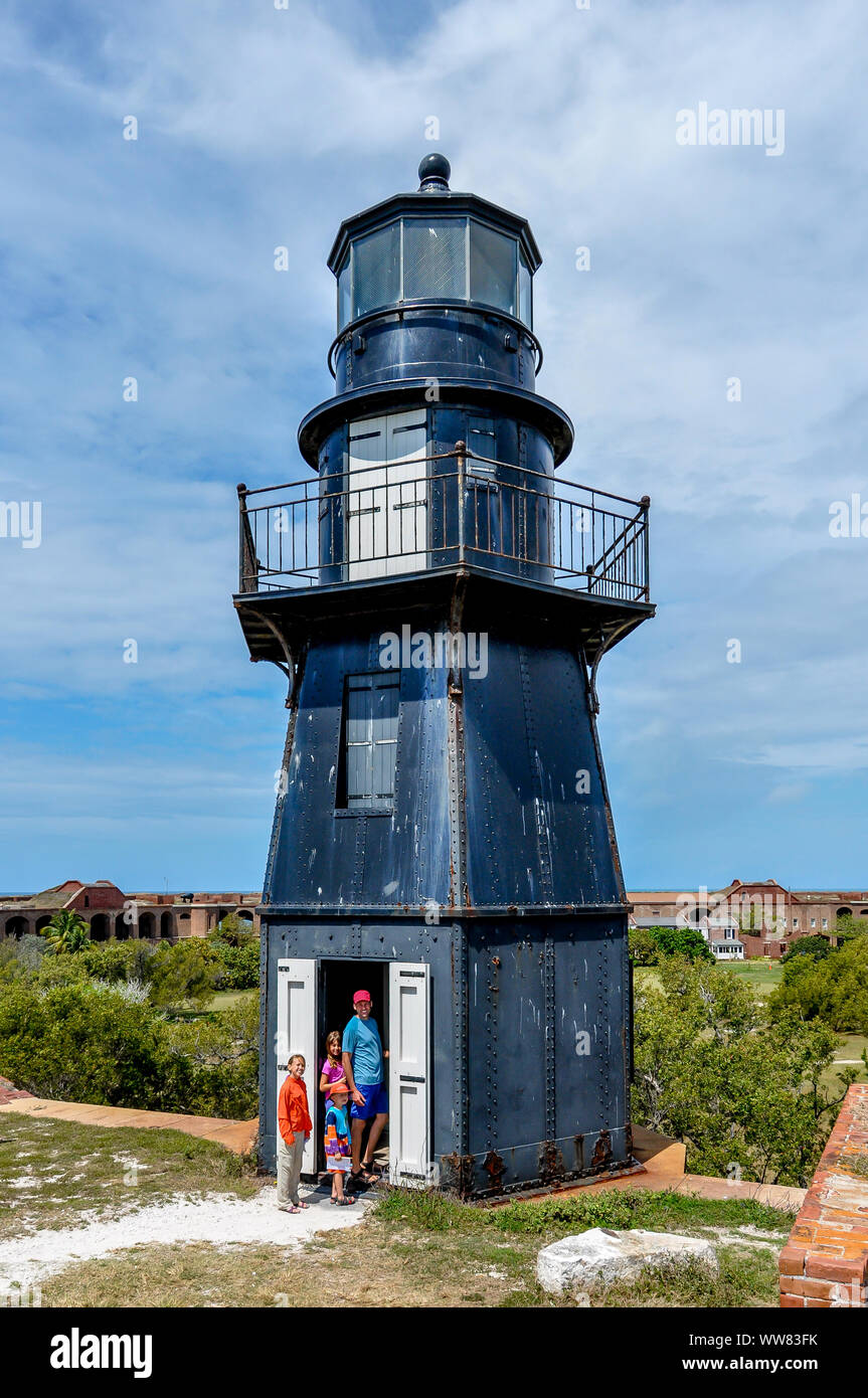 A family stands beside the black lighthouse at Fort Jefferson at Dry Tortugas National Park on a day trip from Key West, Florida. Stock Photo