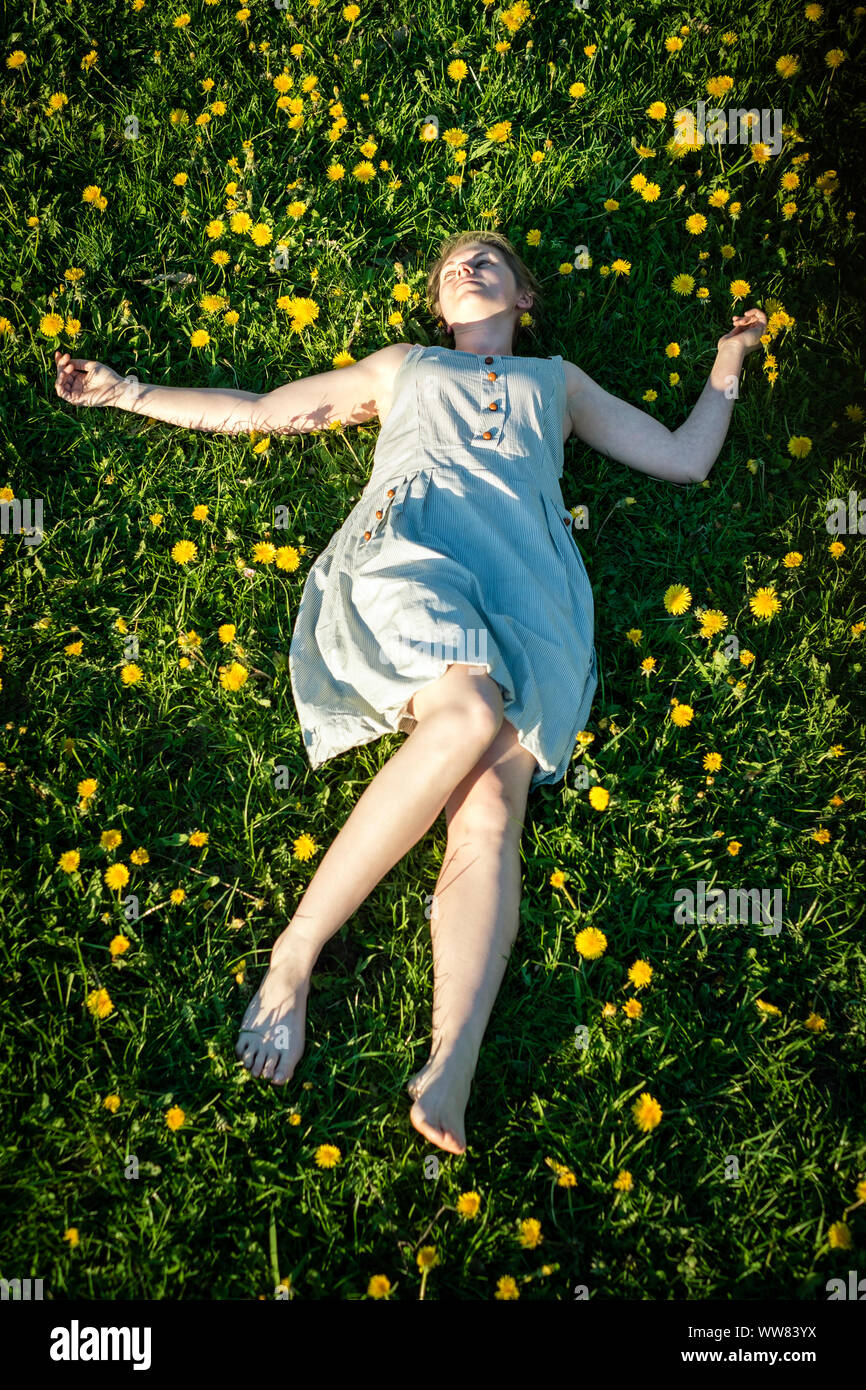 Young woman lying down in dandelion field in early spring in rural France  Stock Photo - Alamy