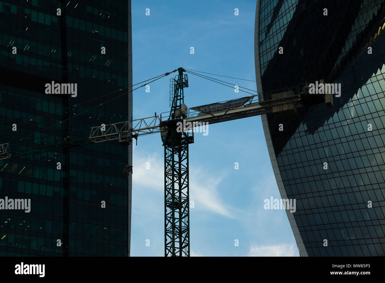 Moscow, Russia - September 12, 2019: Tower construction cranes on the background of glass facades of the buildings of the Moscow City business center Stock Photo