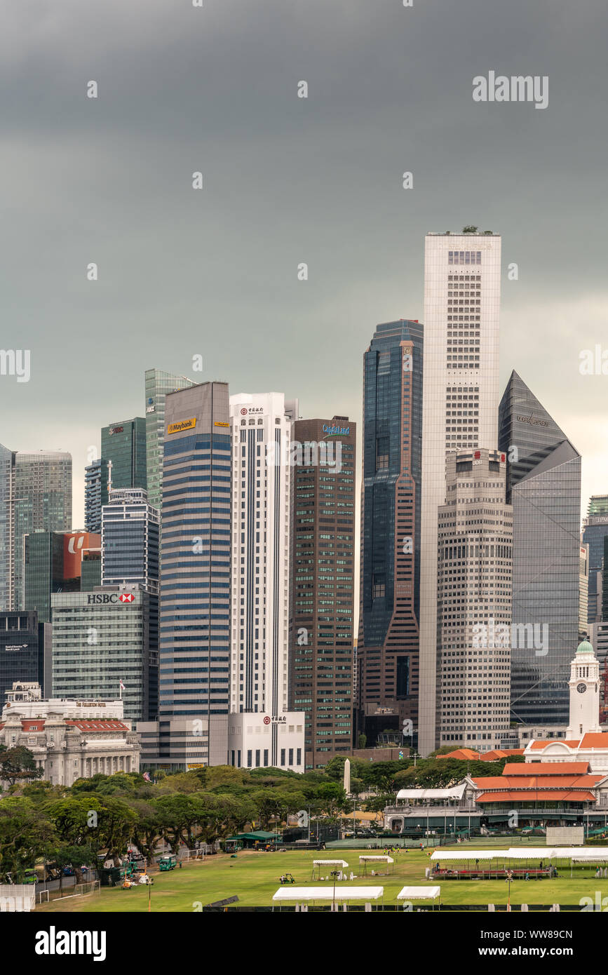 Singapore - March 20, 2019: Partial portrait of financial district skyscrapers from HSBC to Onerafflespace buildings under dark gray cloudscape. Victo Stock Photo