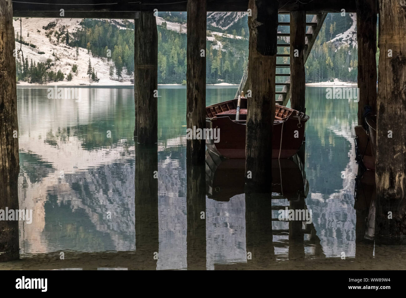 Autumn hike around the Pragser Wildsee in the Dolomites, Italy. Rowing boat by the boathouse, pile dwelling. Stock Photo