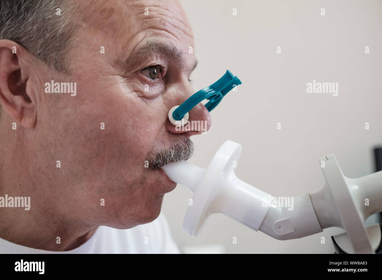 Senior hispanic man man testing breathing function by spirometry ...