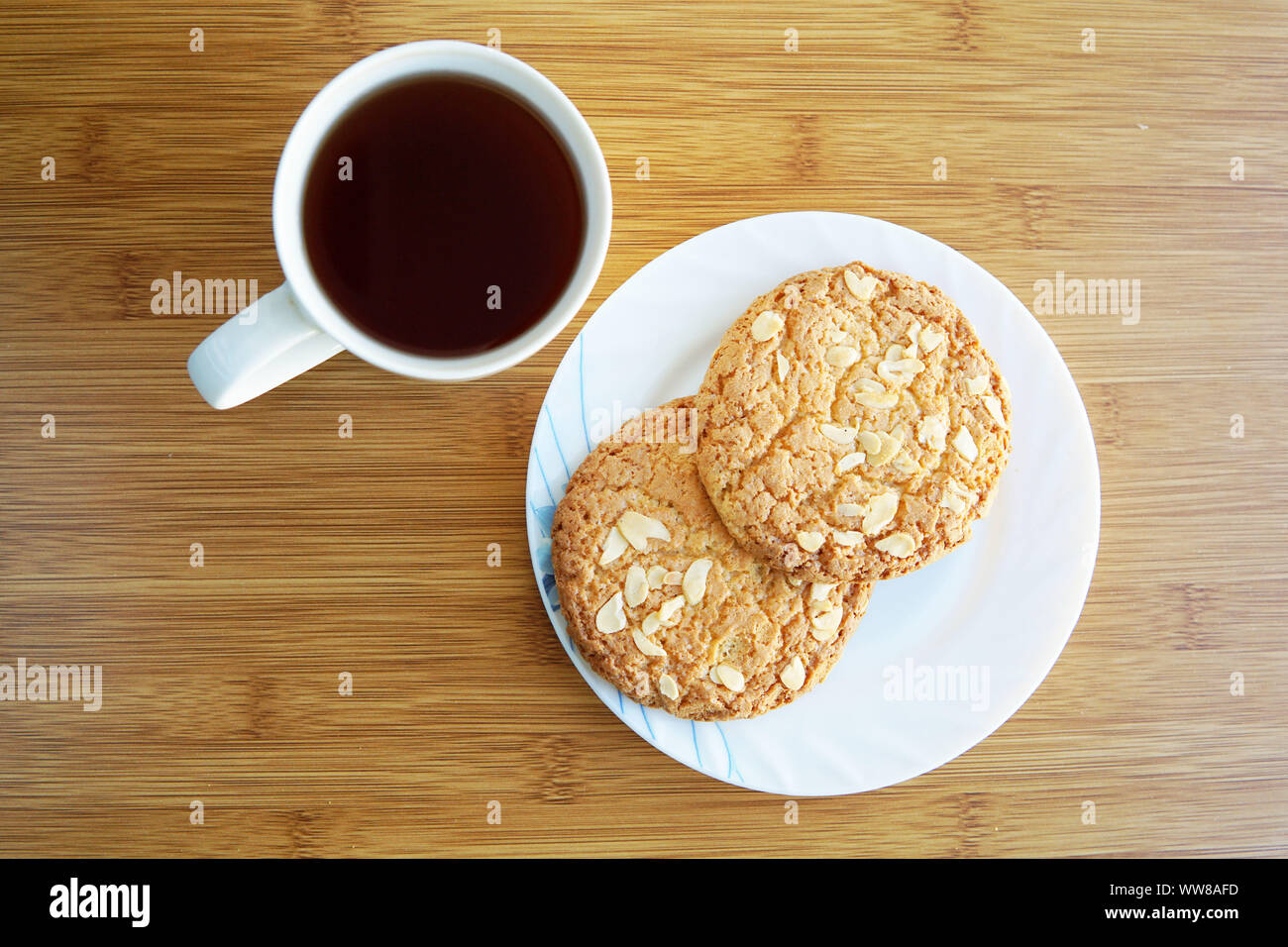 Cup of tea and saucer with cookies with nuts on the table. Top view. Stock Photo