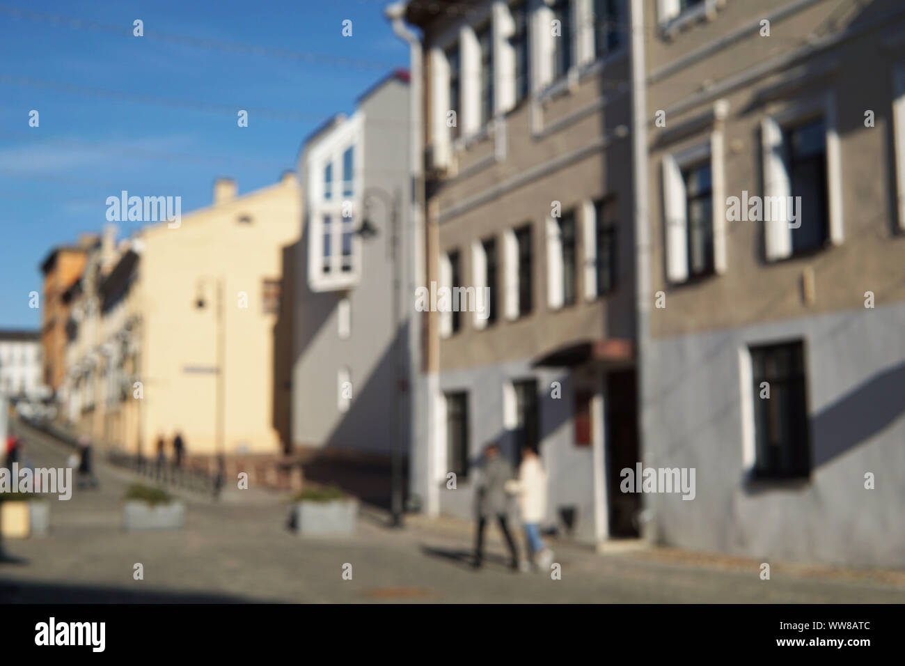Couple of people on the street with old buildings on the background. Stock Photo